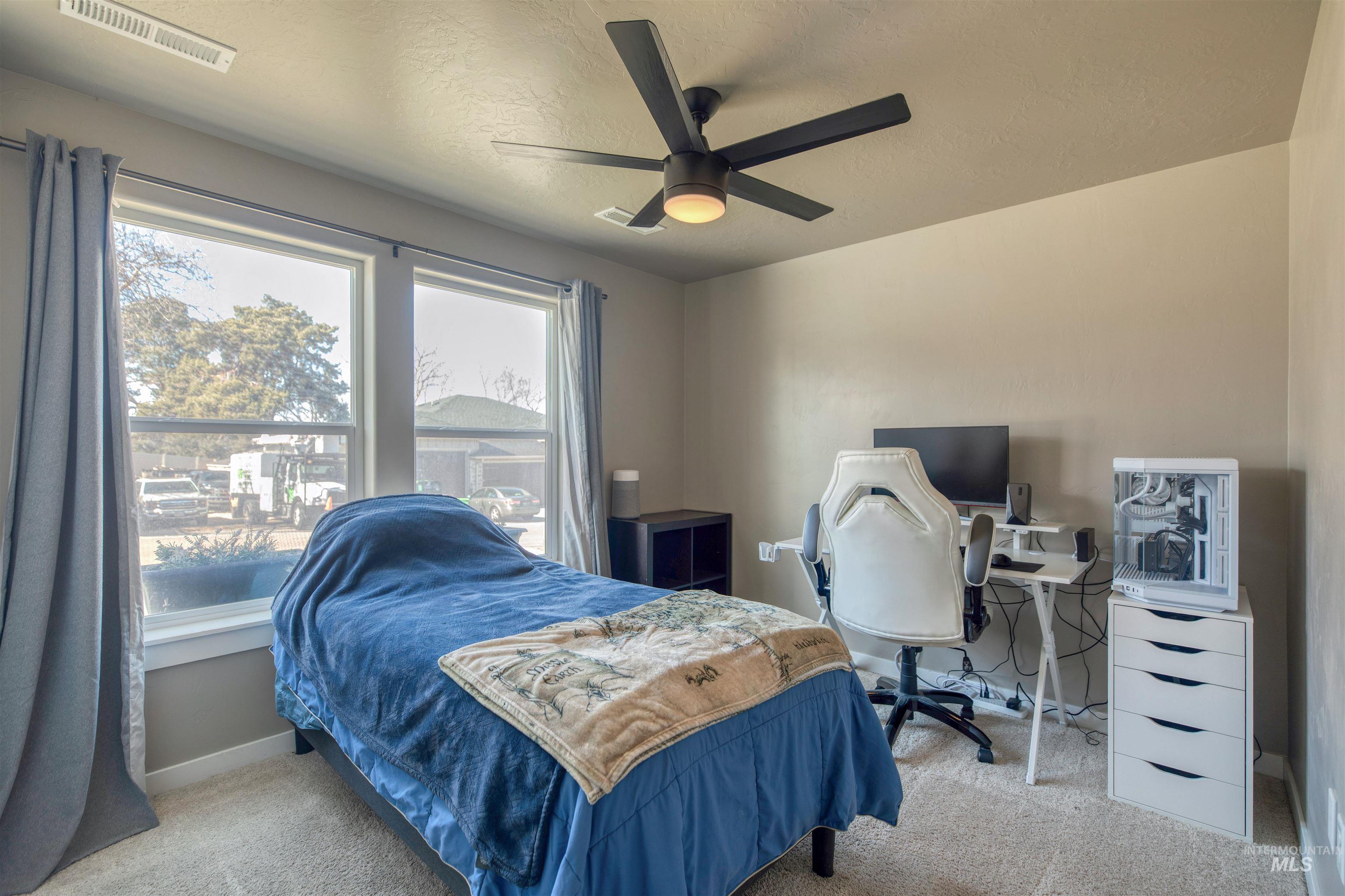 Bedroom with ceiling fan, light carpet, a textured ceiling, and an office area