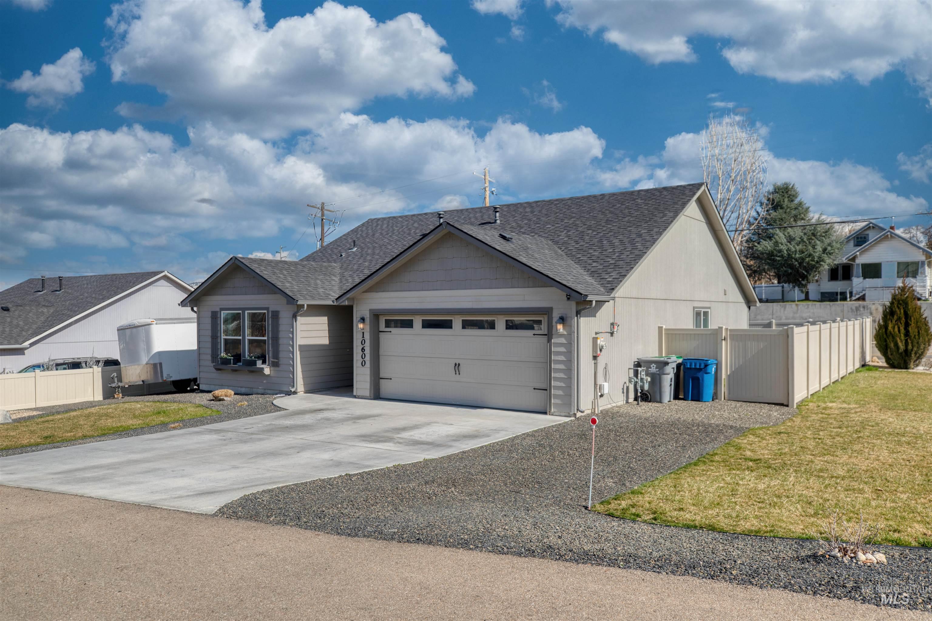 Ranch-style house with a garage, concrete driveway, and a shingled roof