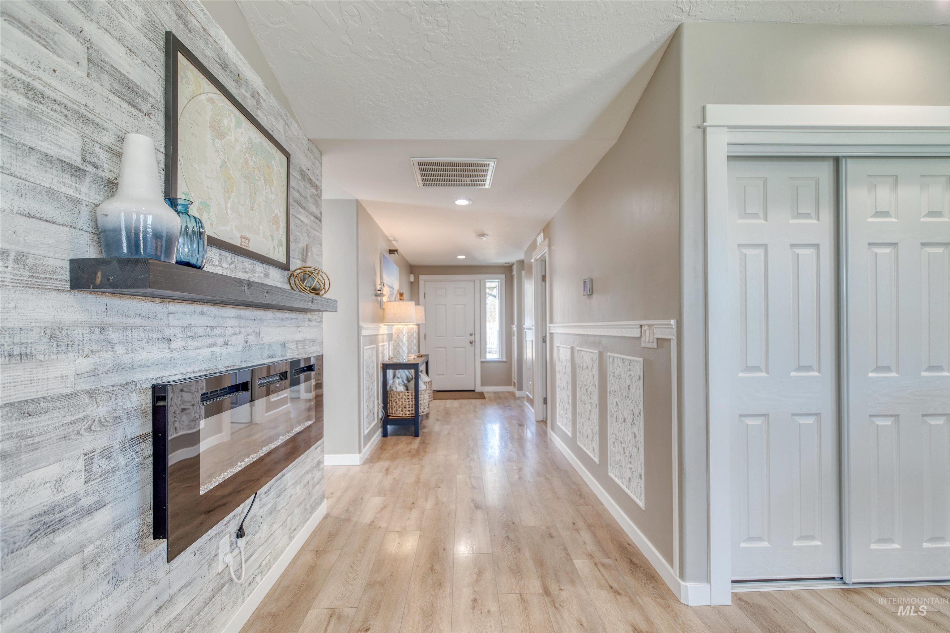 Hall featuring light wood finished floors, recessed lighting, and a textured ceiling