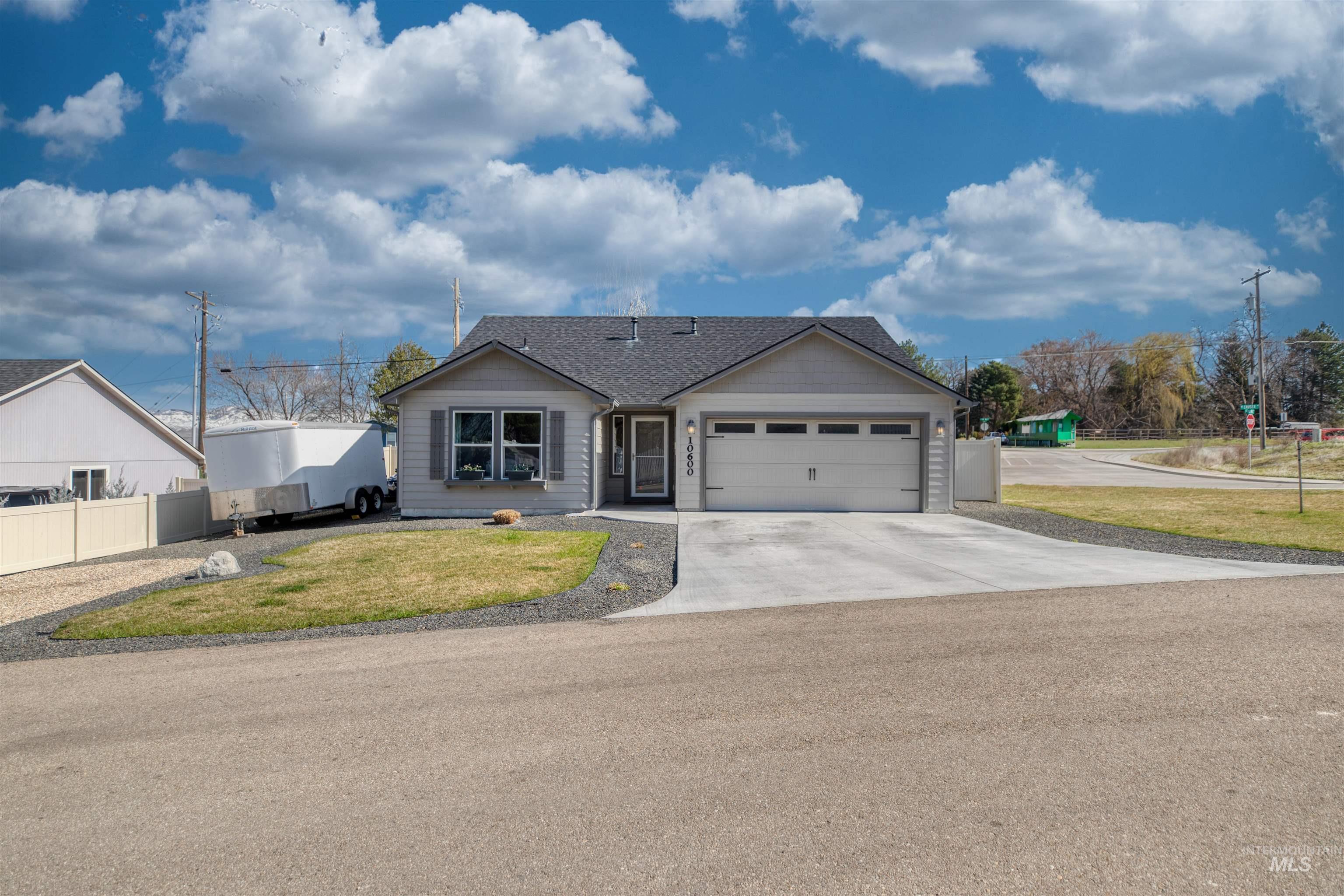 Single story home with concrete driveway, a garage, and a shingled roof