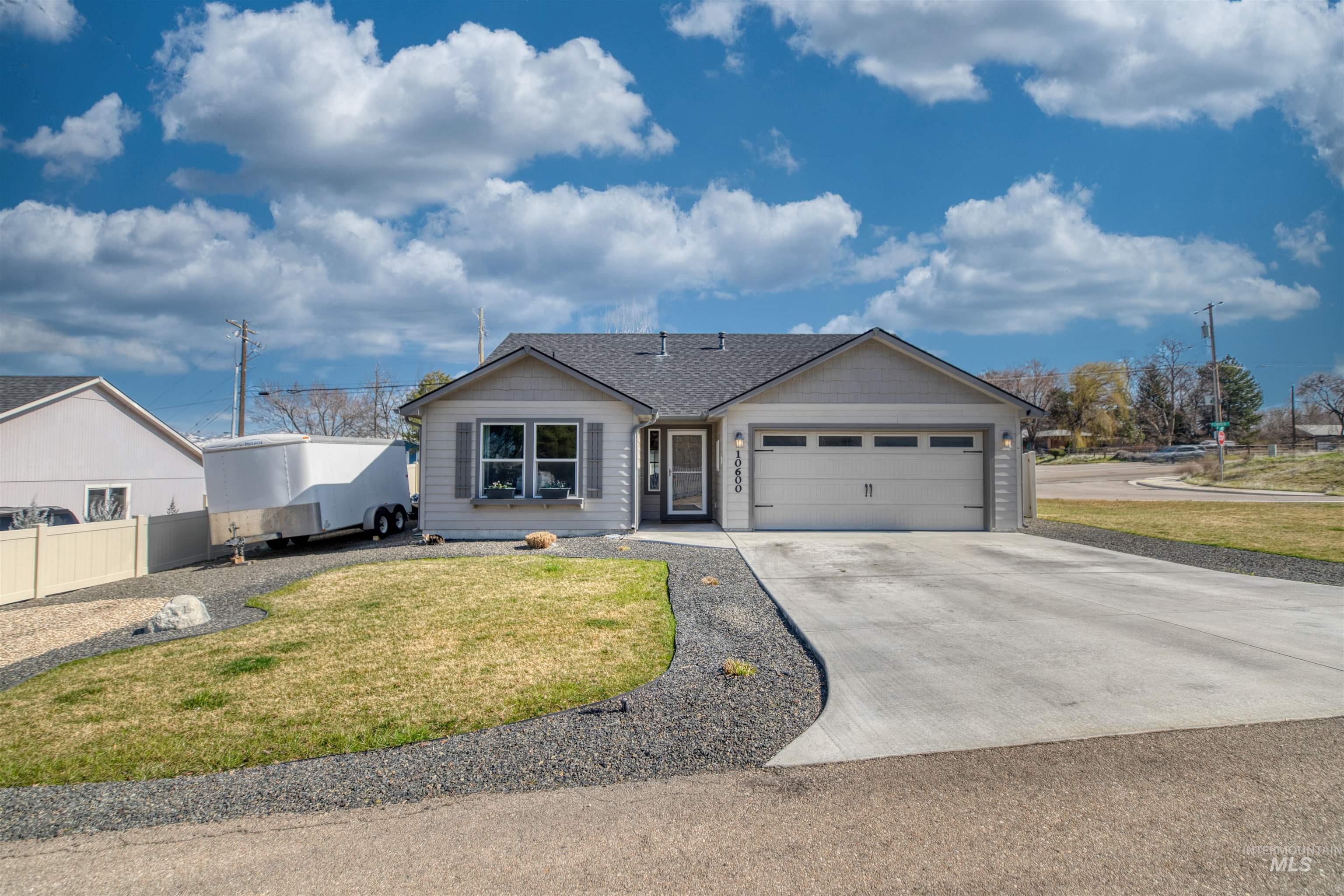 Single story home with a garage, concrete driveway, a front yard, and roof with shingles