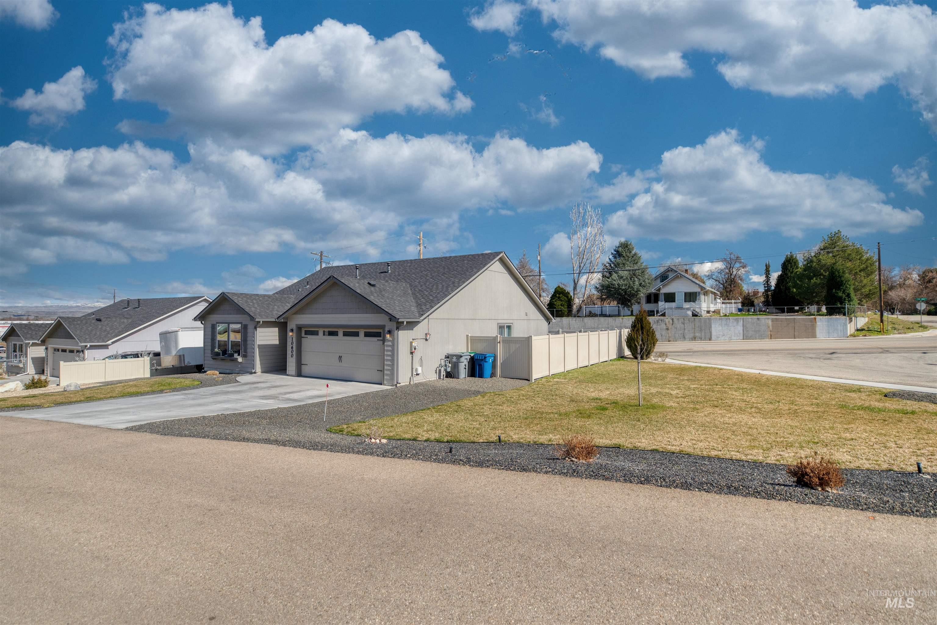 View of front of home with a residential view, an attached garage, and driveway