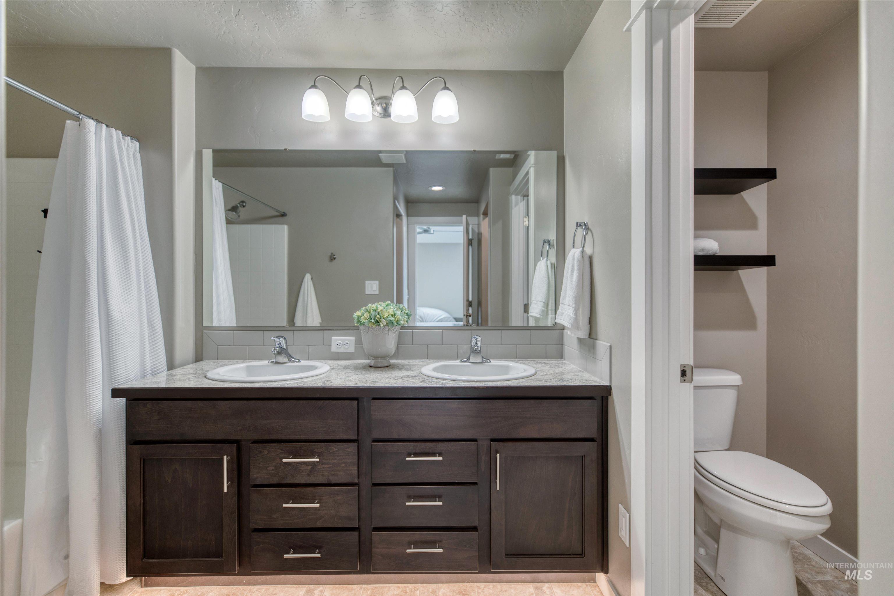 Bathroom with double vanity and decorative backsplash