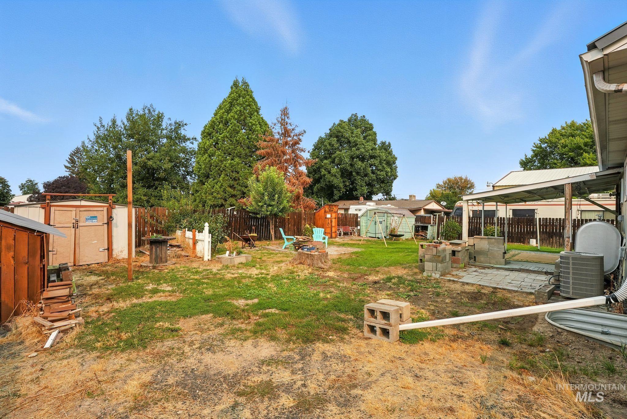 Fenced backyard featuring a storage shed and a patio area
