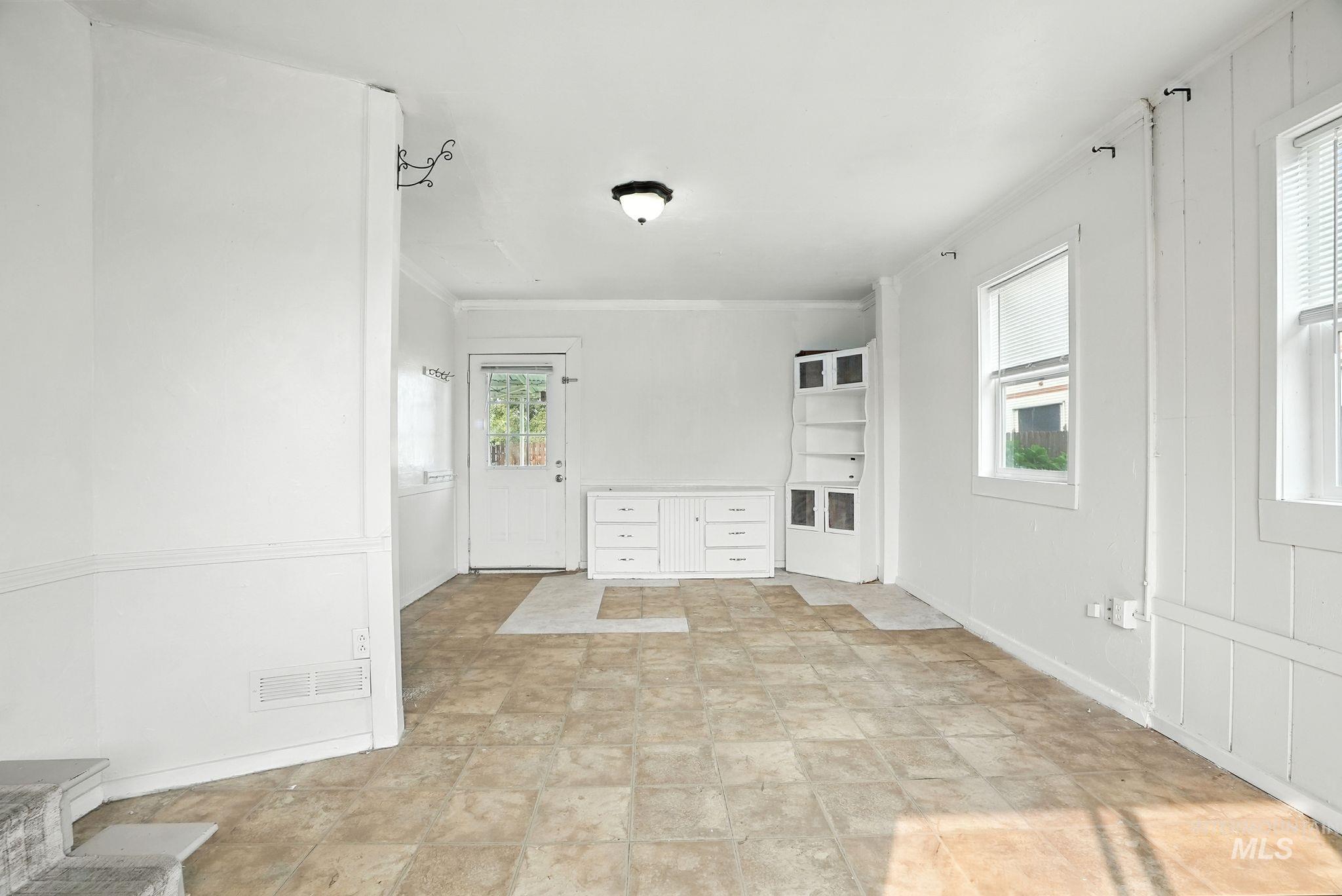 Entryway with crown molding and baseboards
