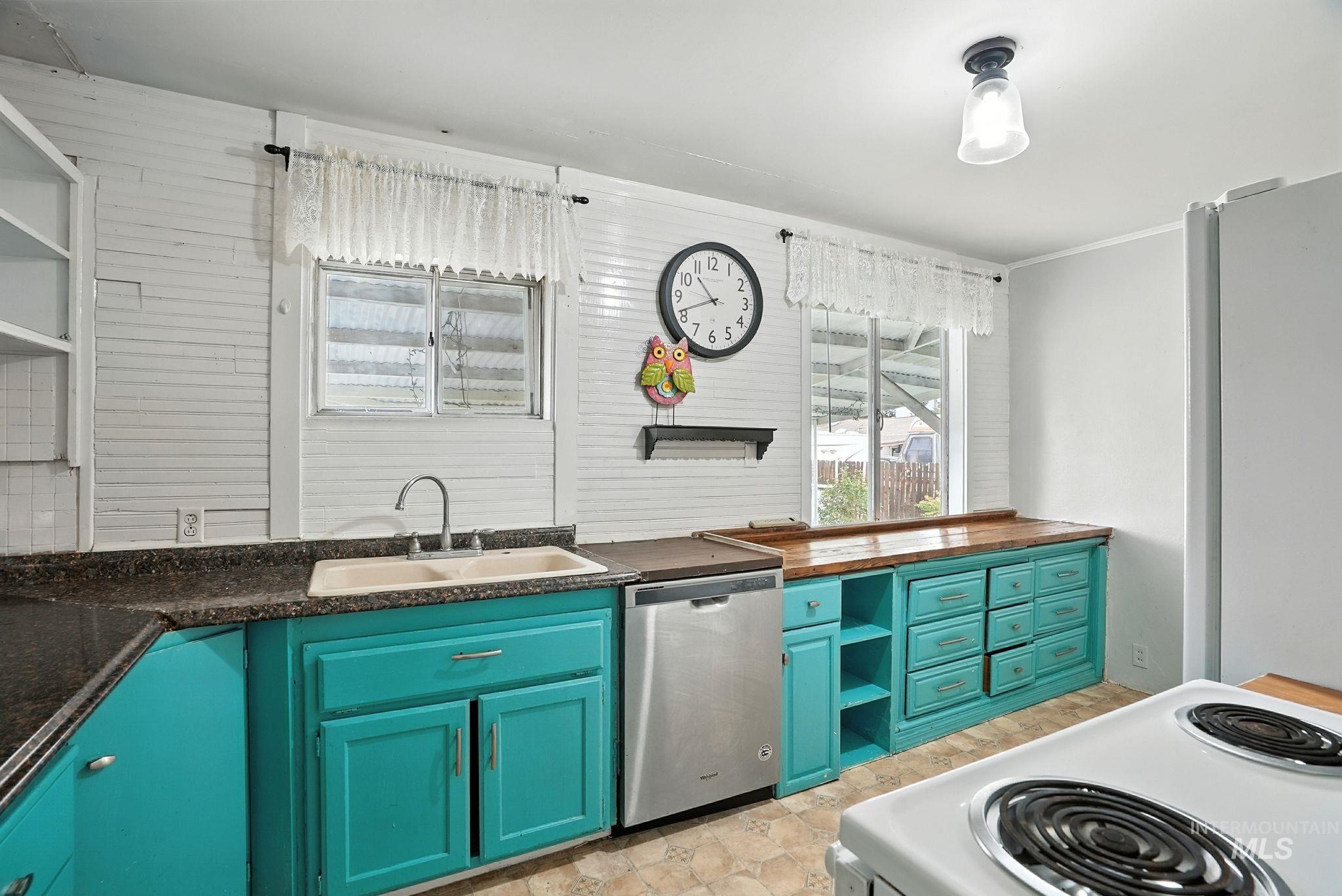 Kitchen with open shelves, dishwasher, and white range with electric cooktop