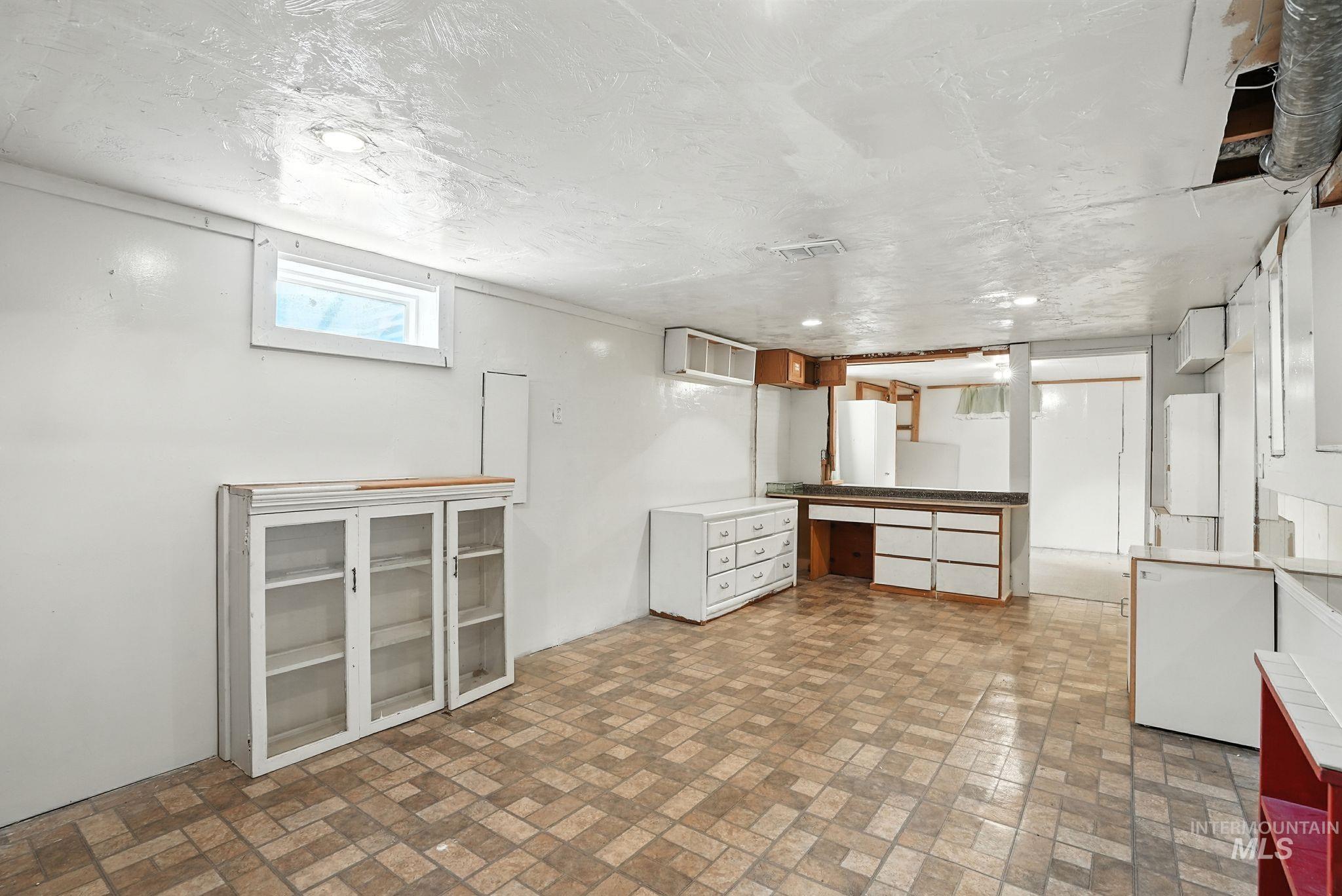Basement with brick patterned flooring and a textured ceiling