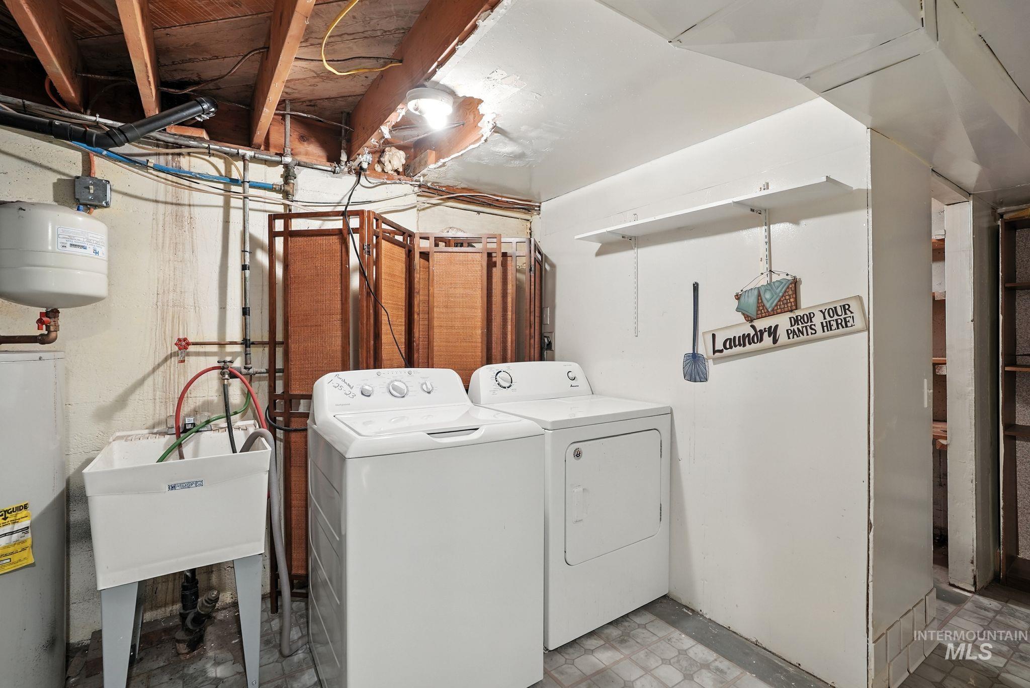 Laundry room with water heater and washing machine and dryer