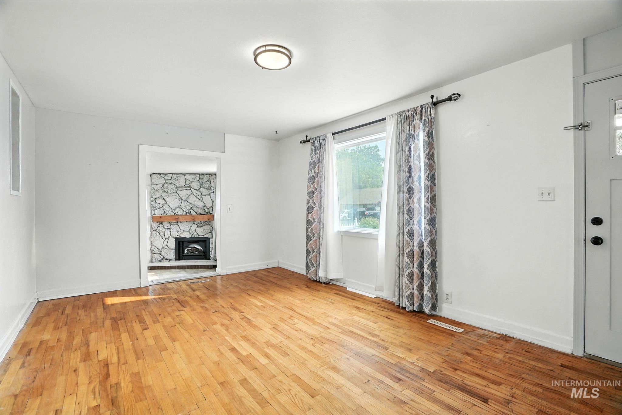 Unfurnished living room featuring a fireplace and light wood-type flooring