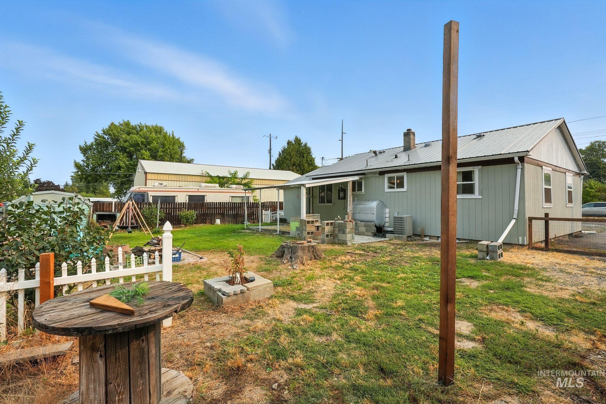 Back of house with a patio area, a metal roof, a fenced backyard, and a chimney