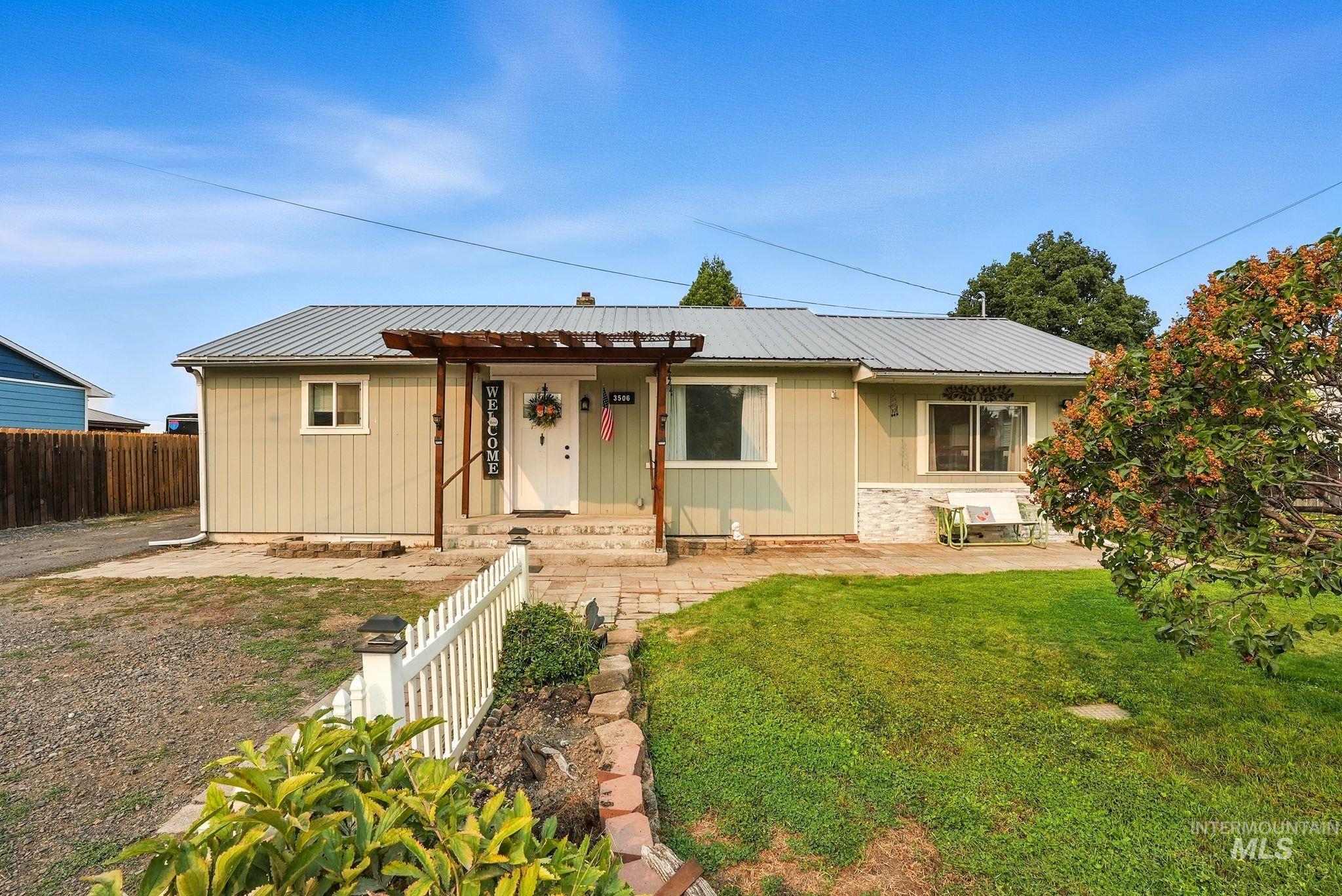 Ranch-style home featuring a patio and a metal roof