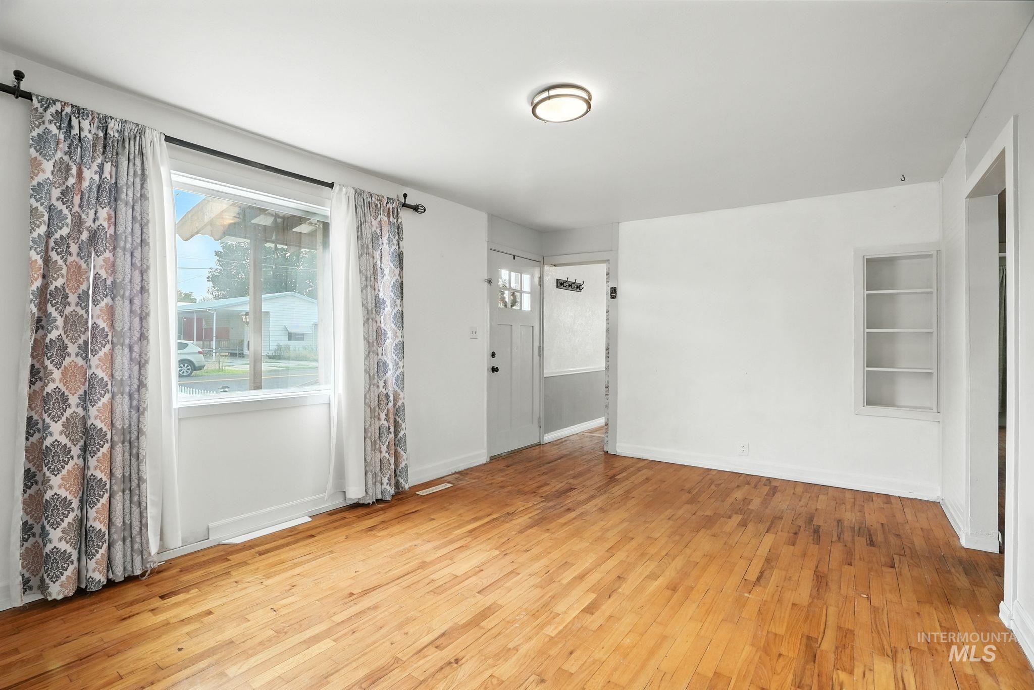Empty room featuring light wood-style floors and built in shelves