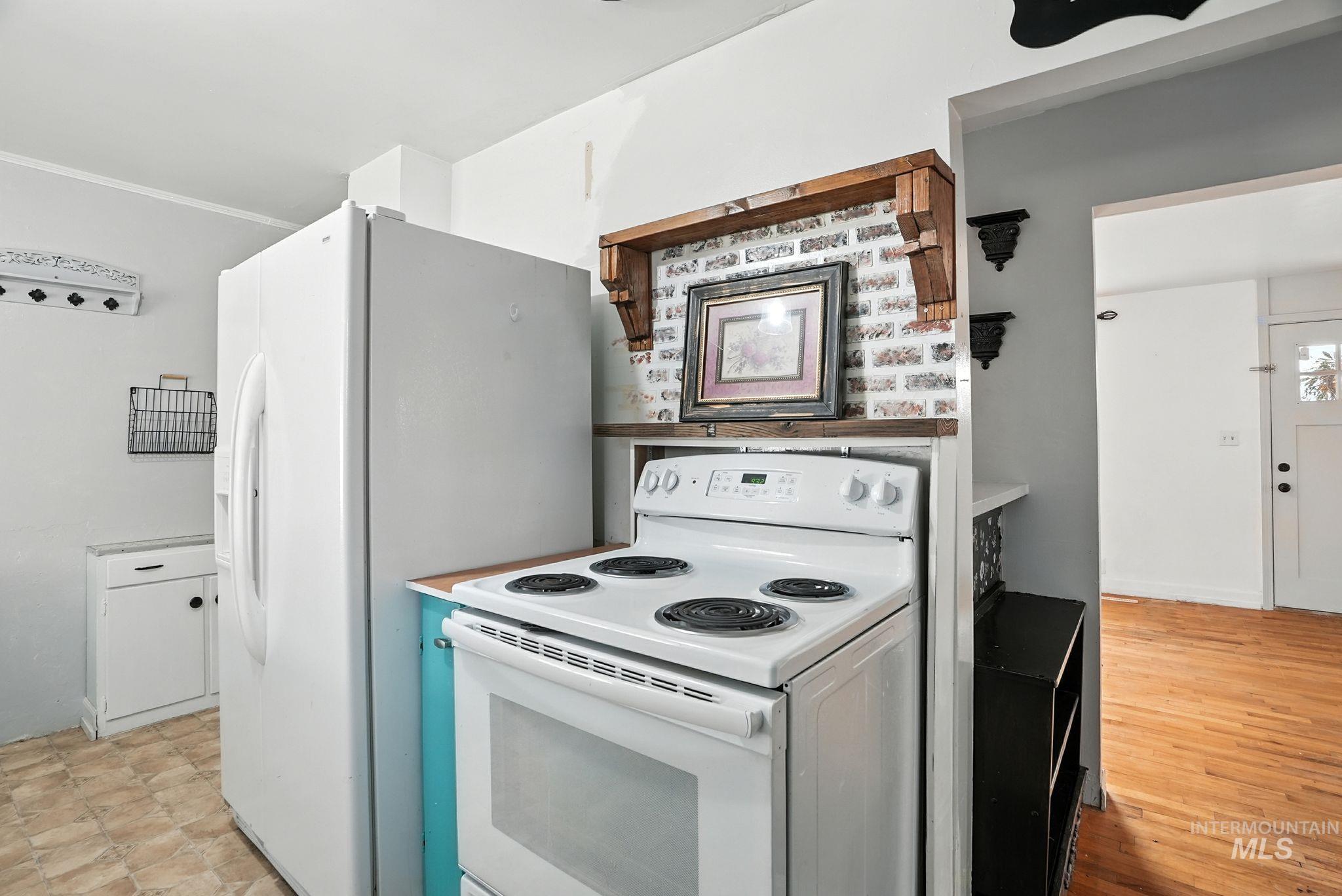 Kitchen with white electric range and light countertops
