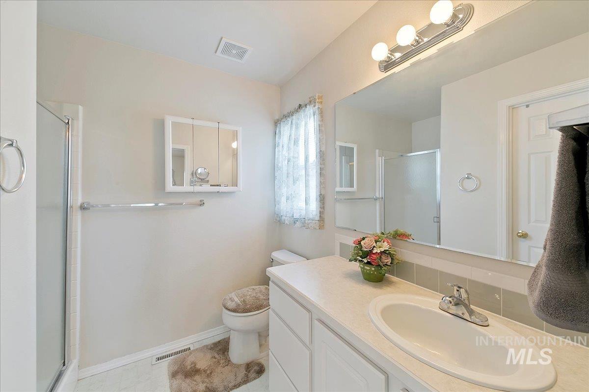 Master Bathroom featuring a shower with shower door and vanity