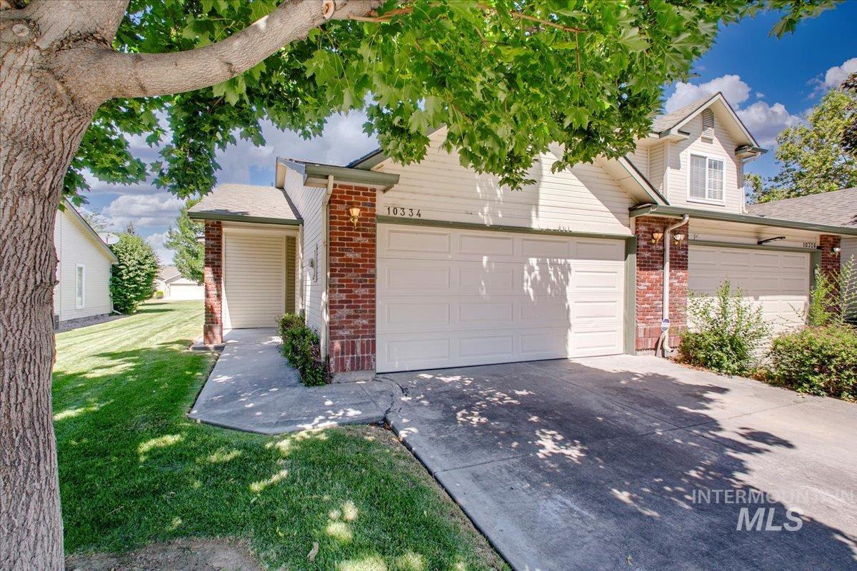 View of front of home with concrete driveway, a garage, brick siding, and a front yard
