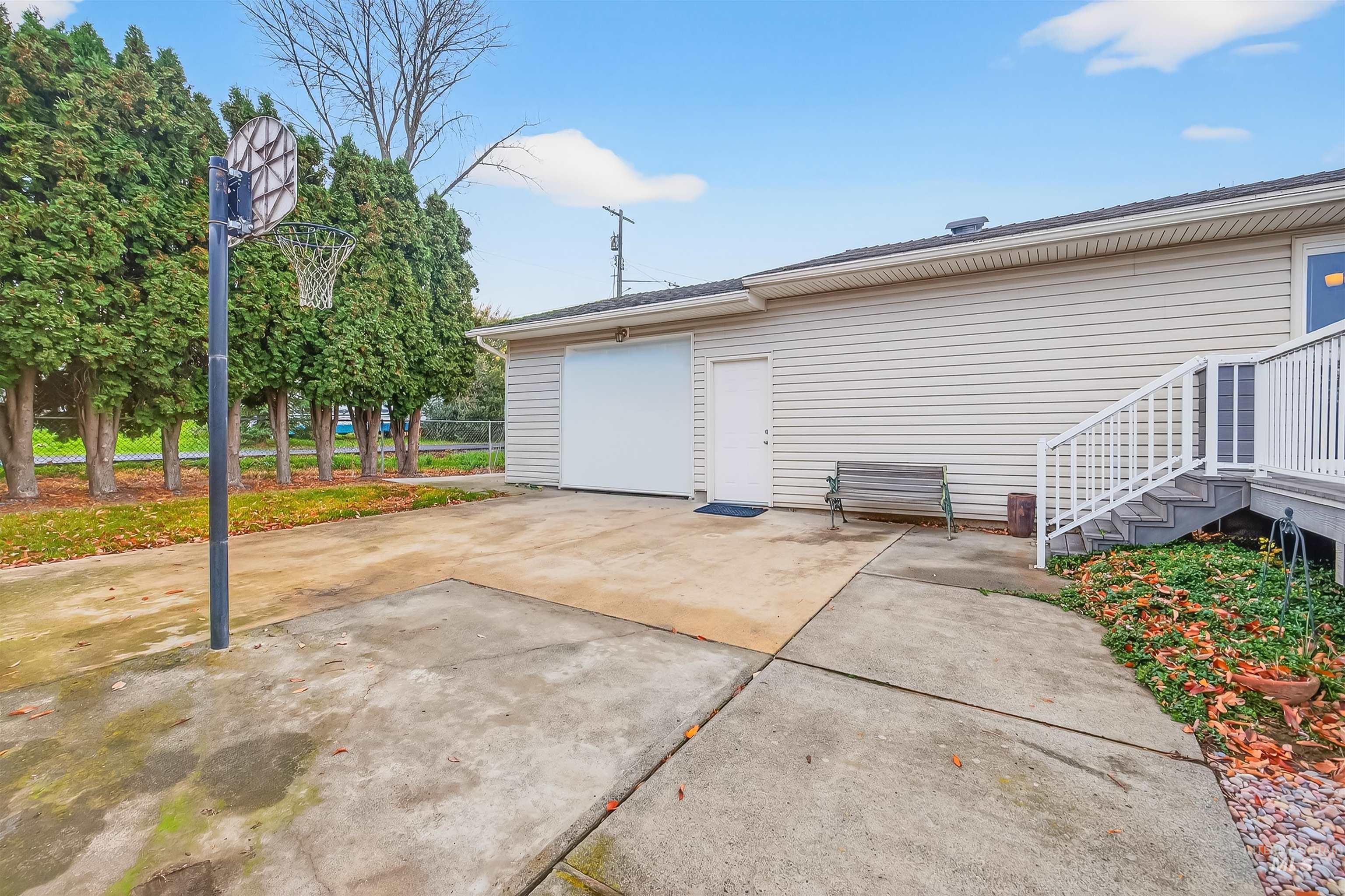 View of property exterior featuring a patio area, driveway, and a garage