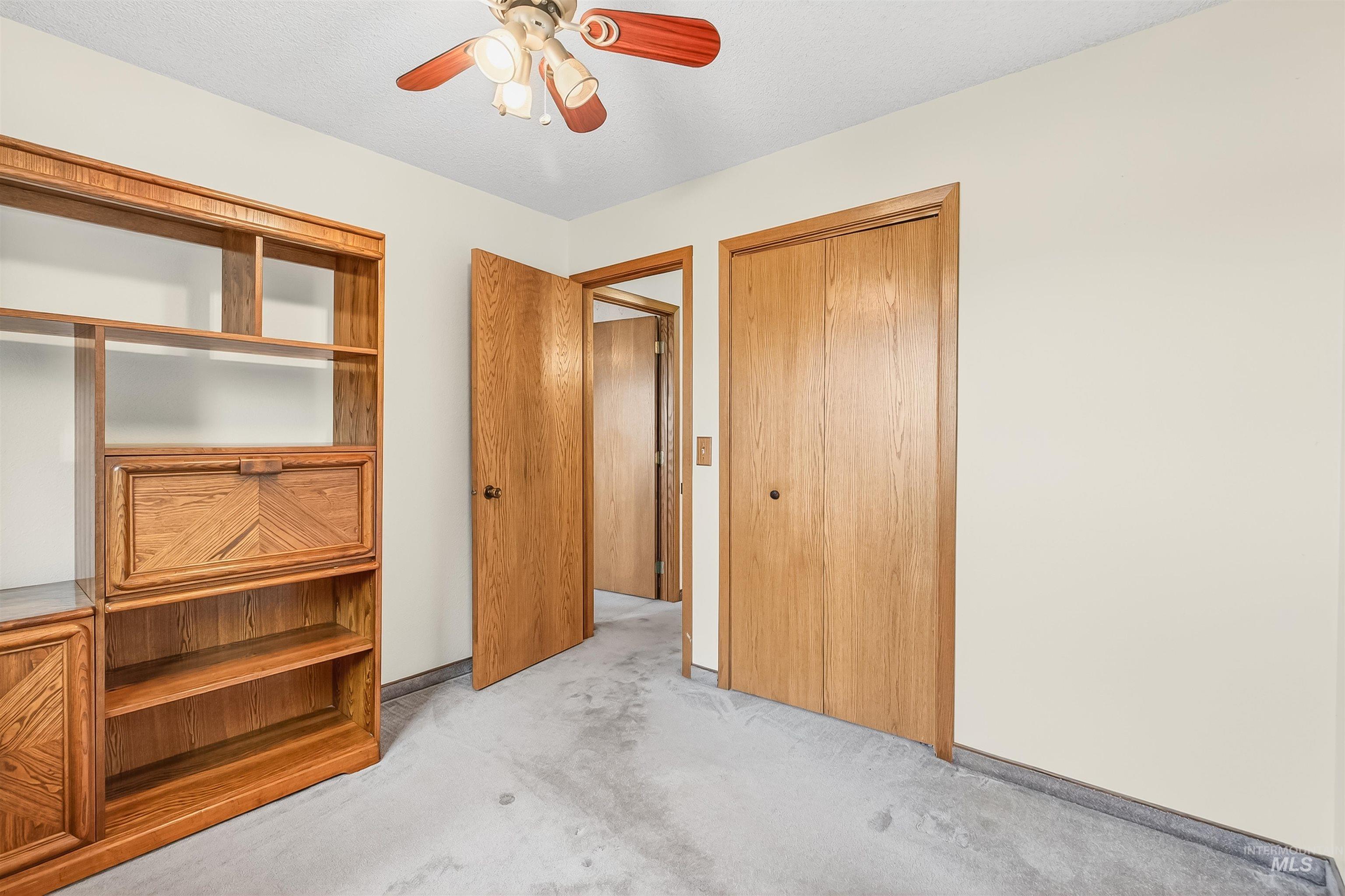 Unfurnished bedroom featuring light colored carpet and ceiling fan