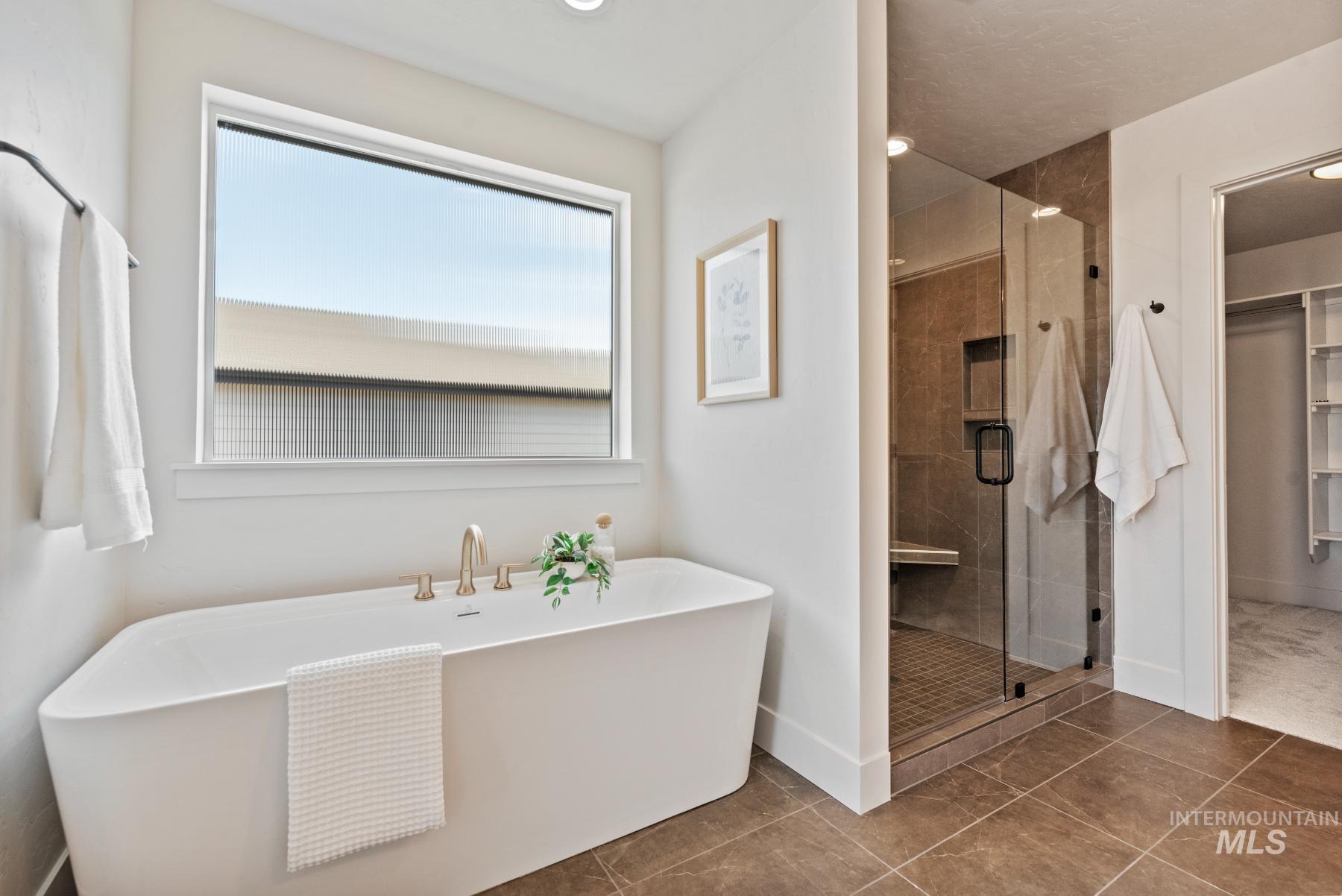 Full bath with a shower stall, tile patterned flooring, a soaking tub, a walk in closet, and recessed lighting