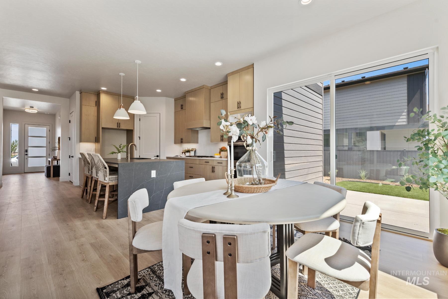 Dining area with light wood-style floors and recessed lighting