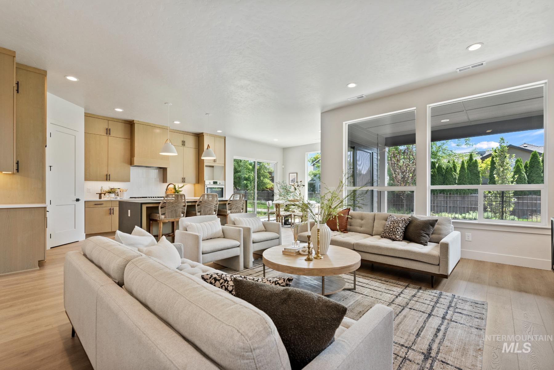 Living area with light wood-type flooring and recessed lighting