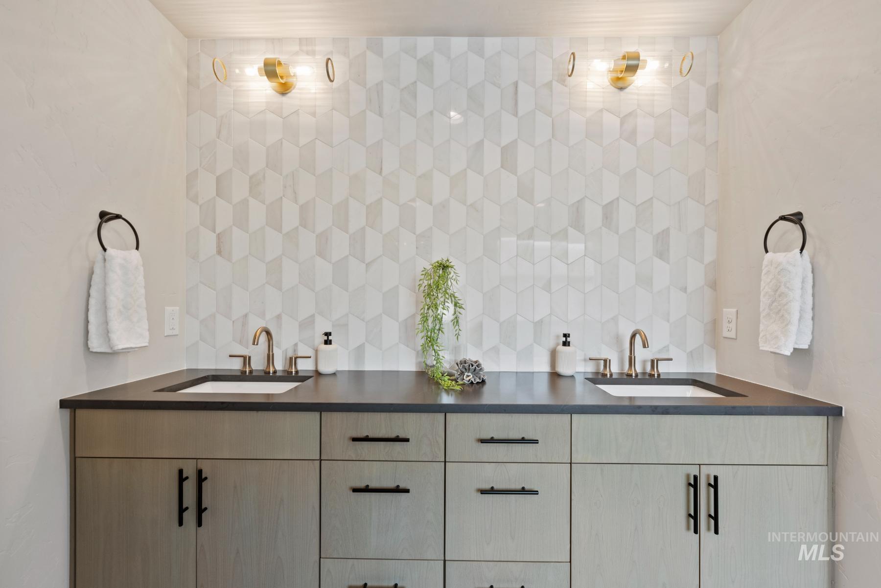 Bathroom featuring double vanity and decorative backsplash