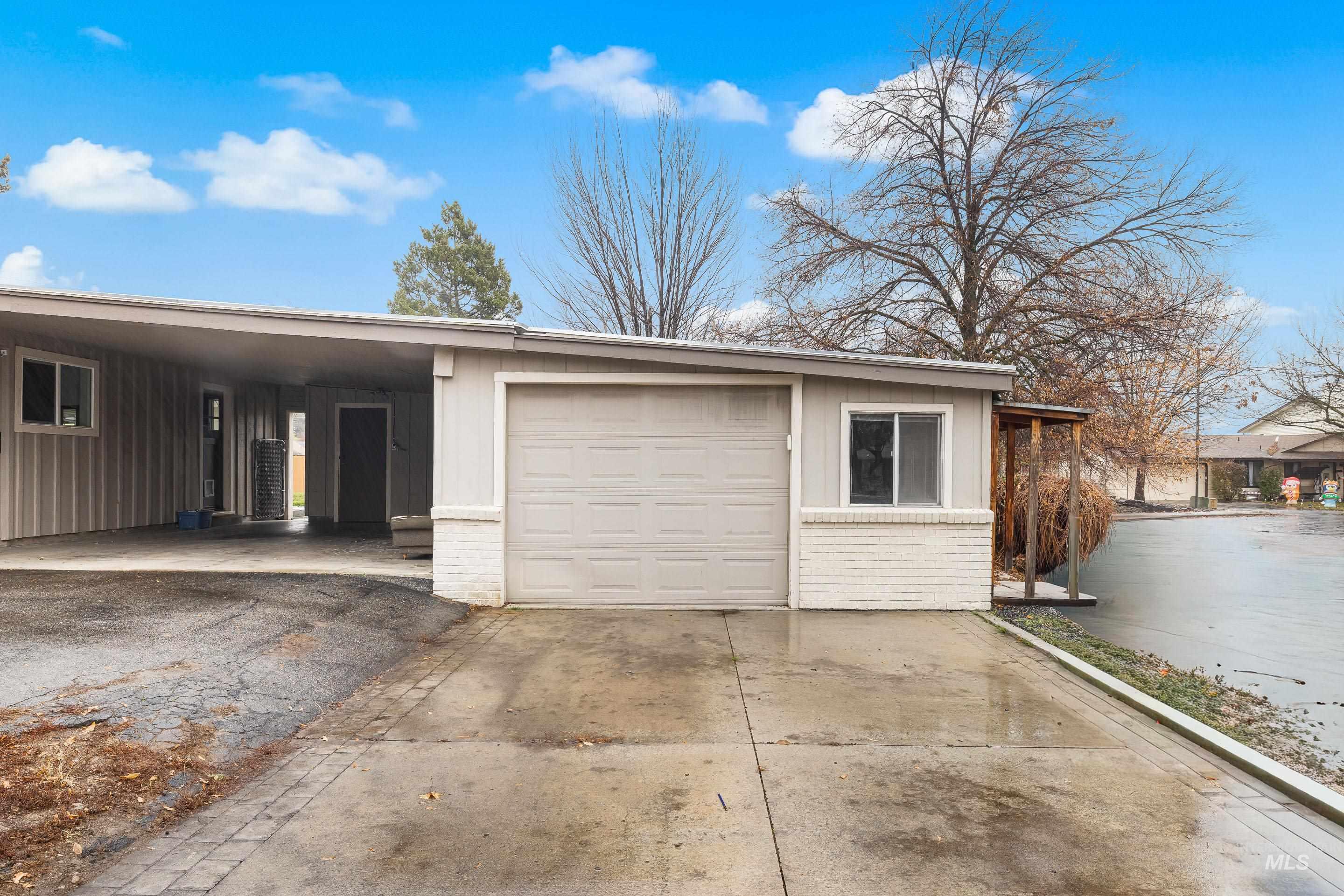 Garage featuring driveway and a carport