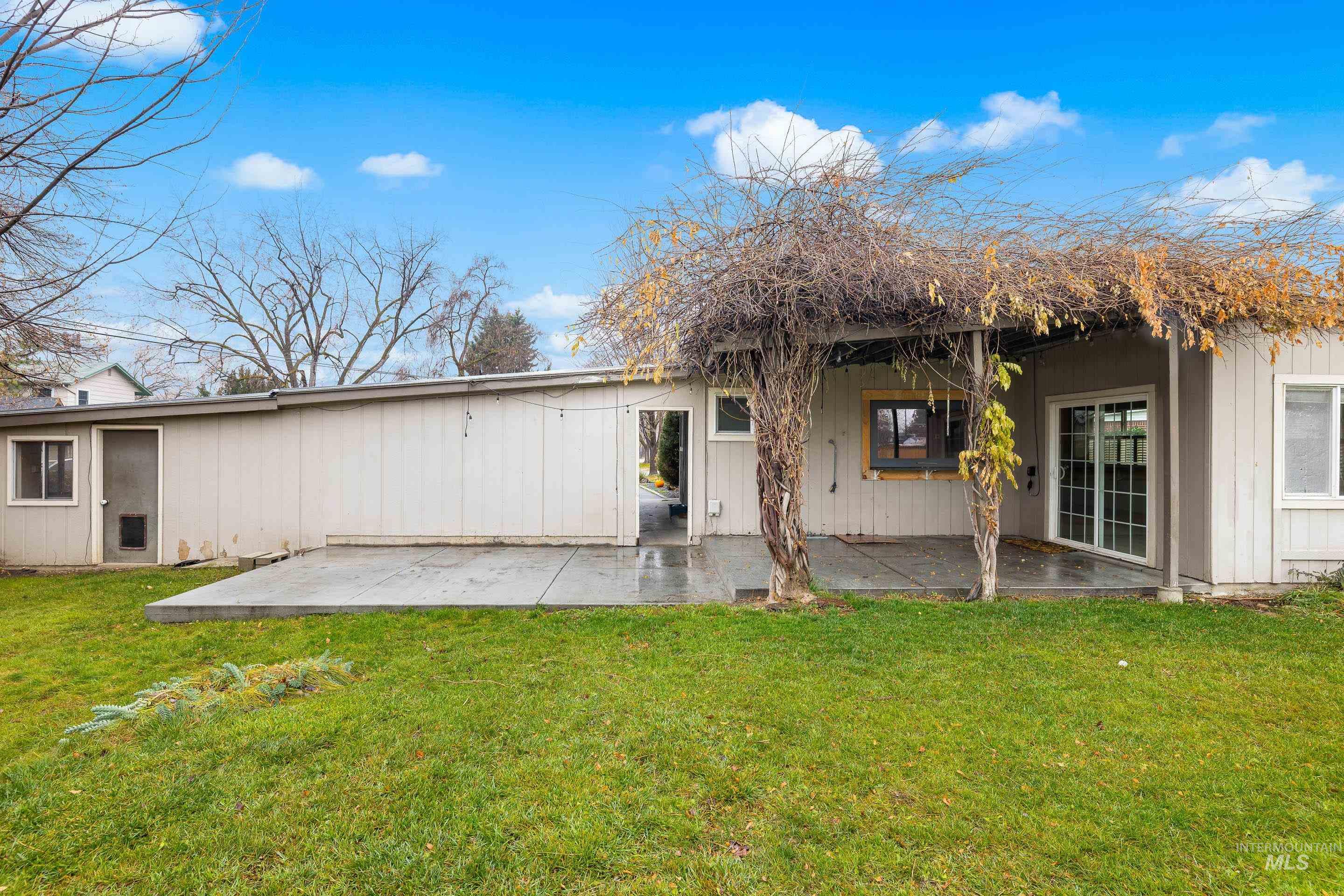 Rear view of house with a patio and a yard