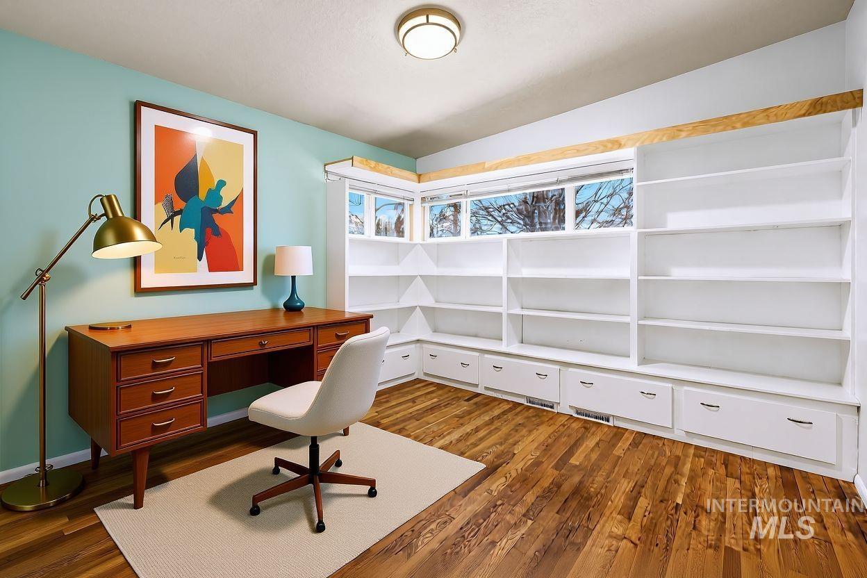 Office with dark wood finished floors and vaulted ceiling