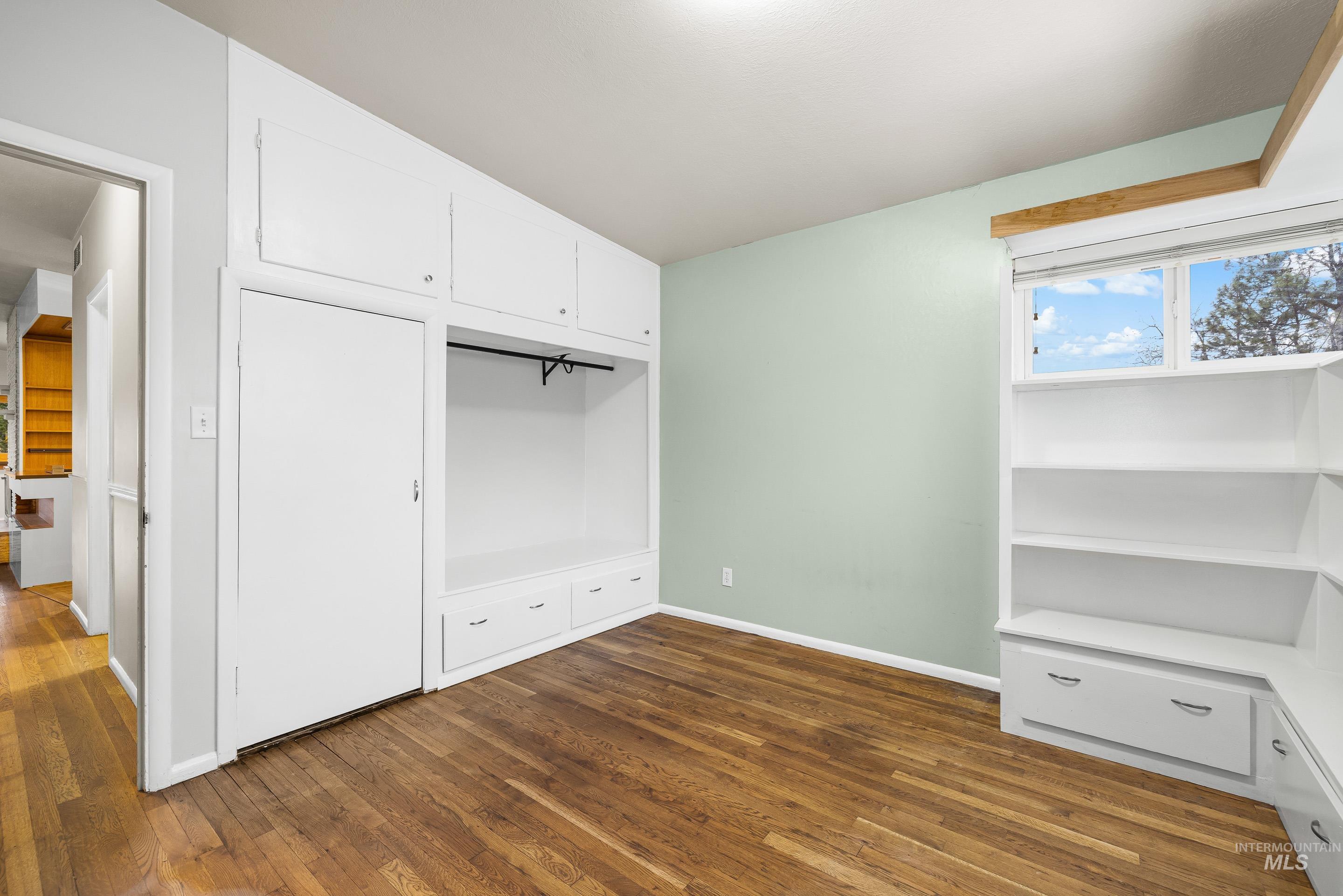 Unfurnished bedroom featuring a closet and dark wood finished floors