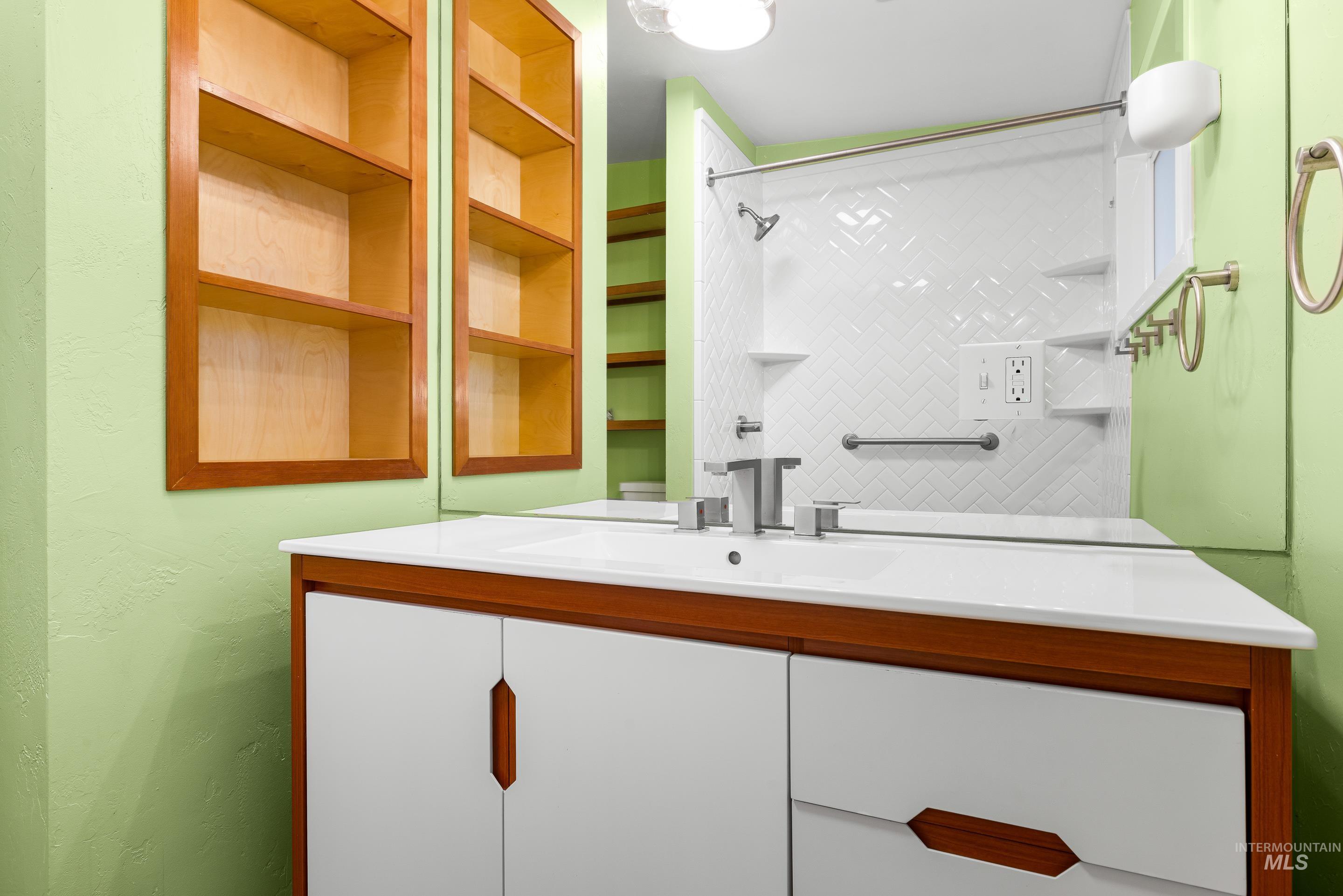 Bathroom featuring vanity and a shower