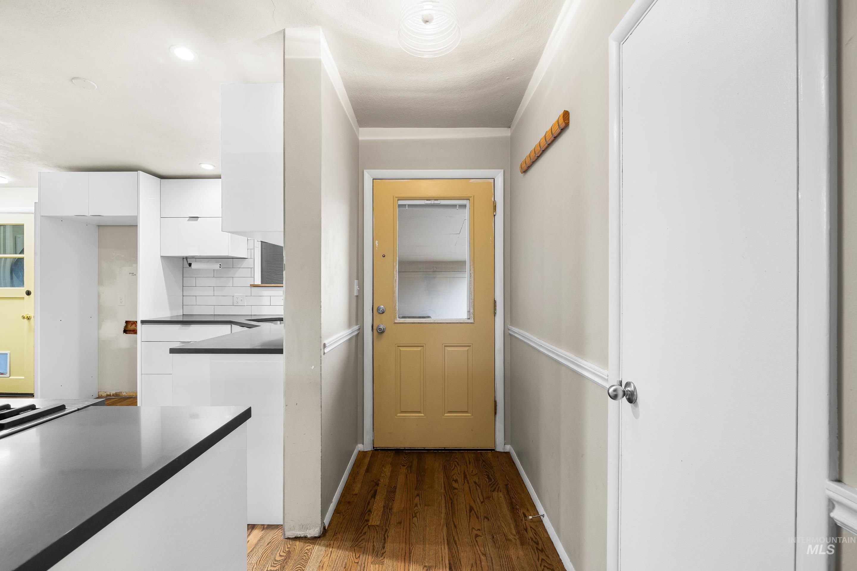 Doorway featuring wood finished floors and recessed lighting