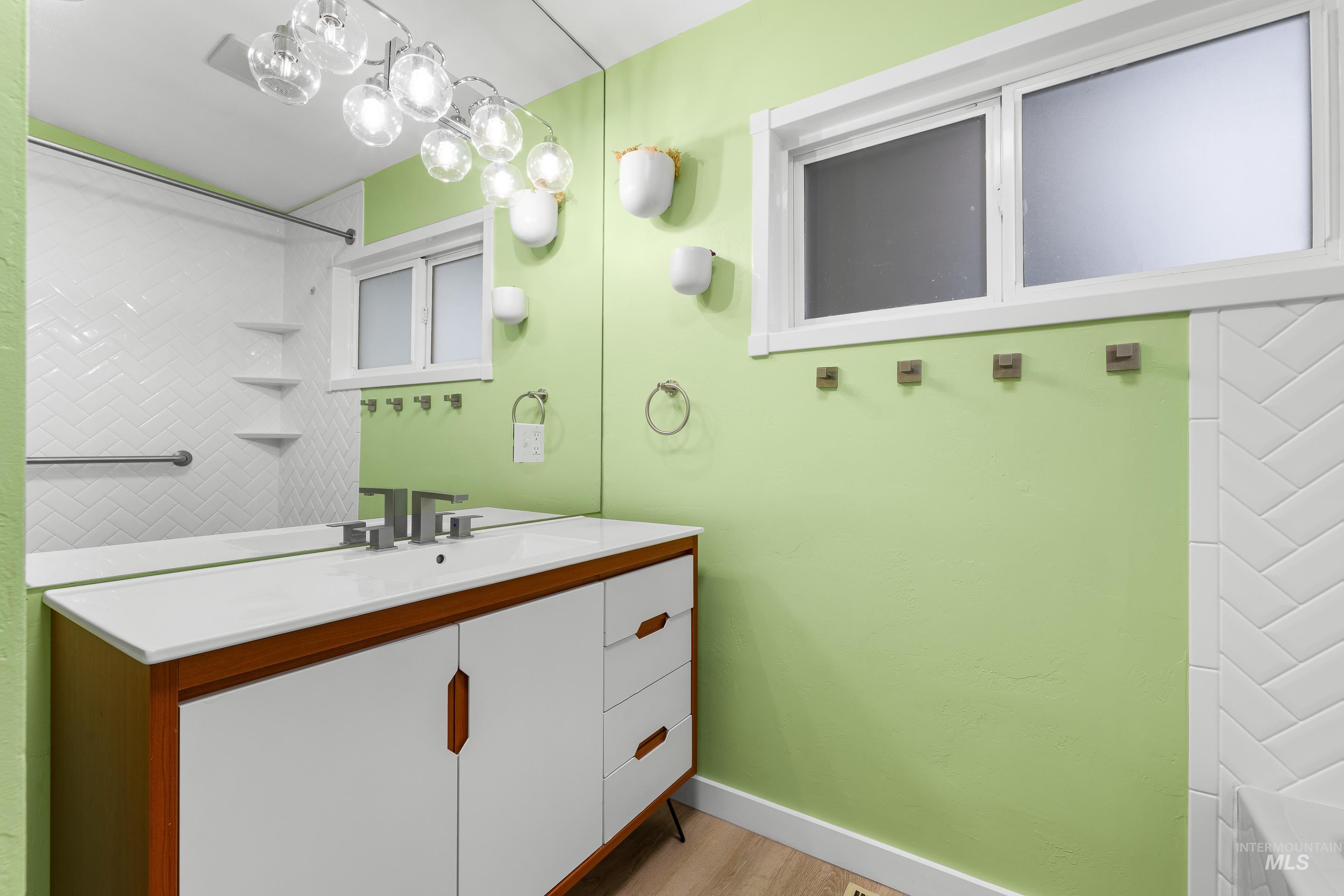 Bathroom with vanity, light wood finished floors, and shower / tub combination