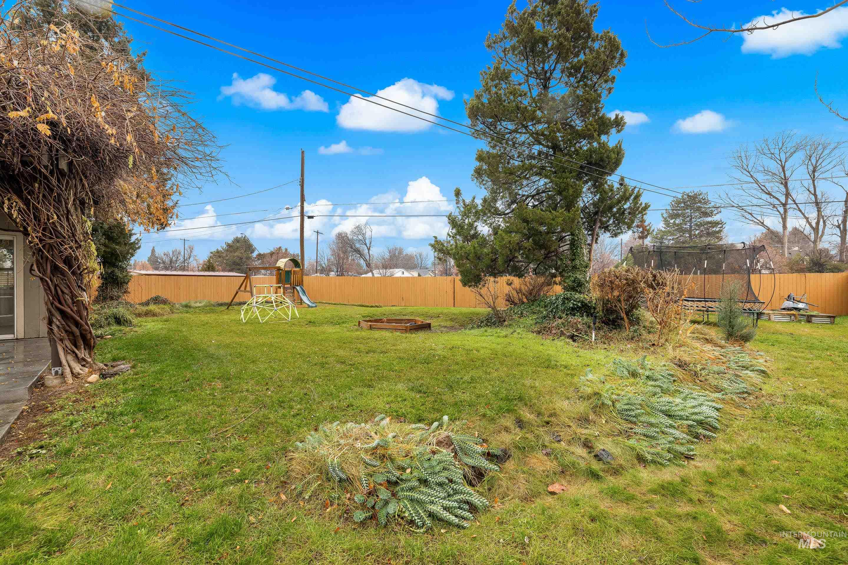 Fenced backyard featuring a playground