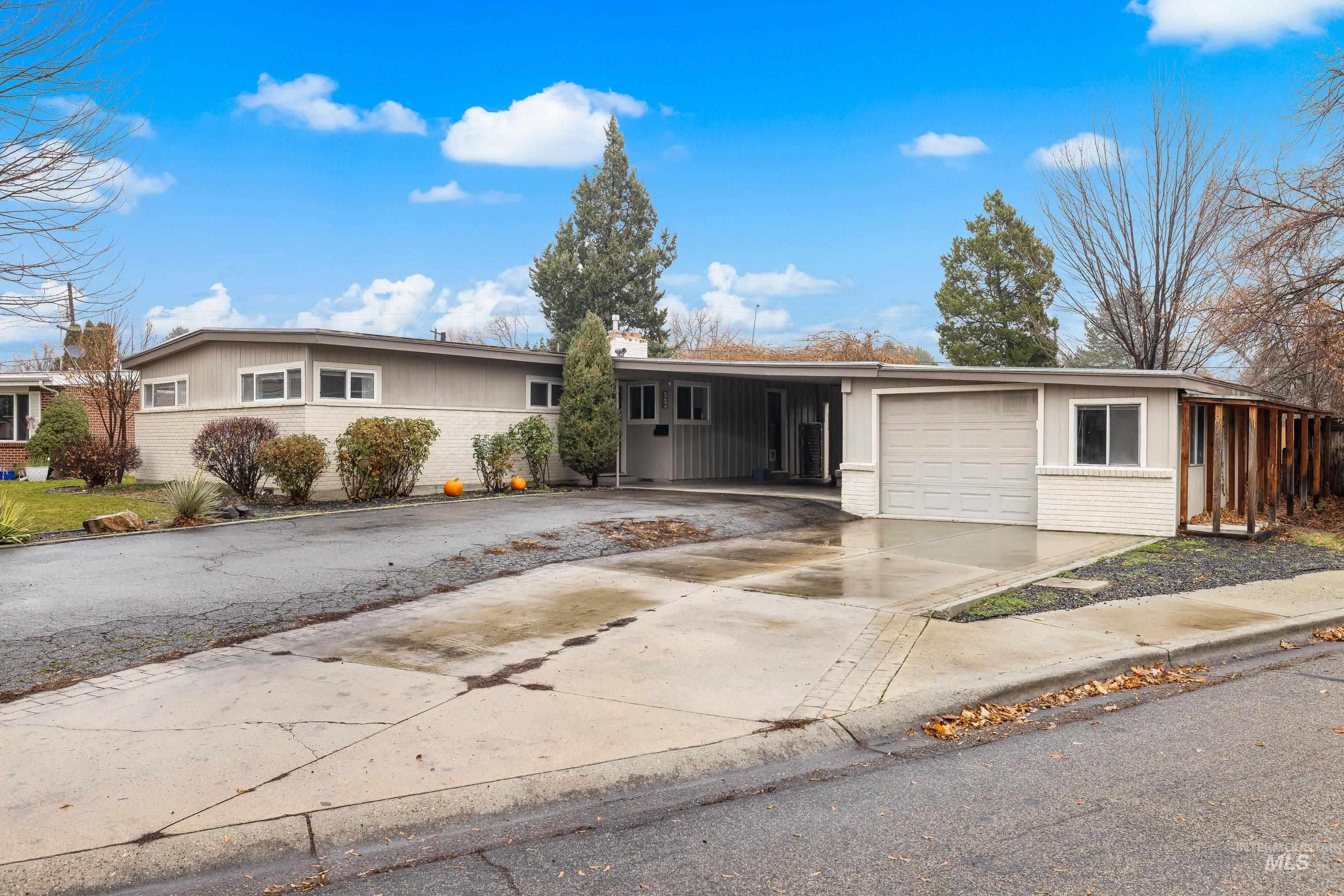 Single story home with brick siding, concrete driveway, and an attached carport