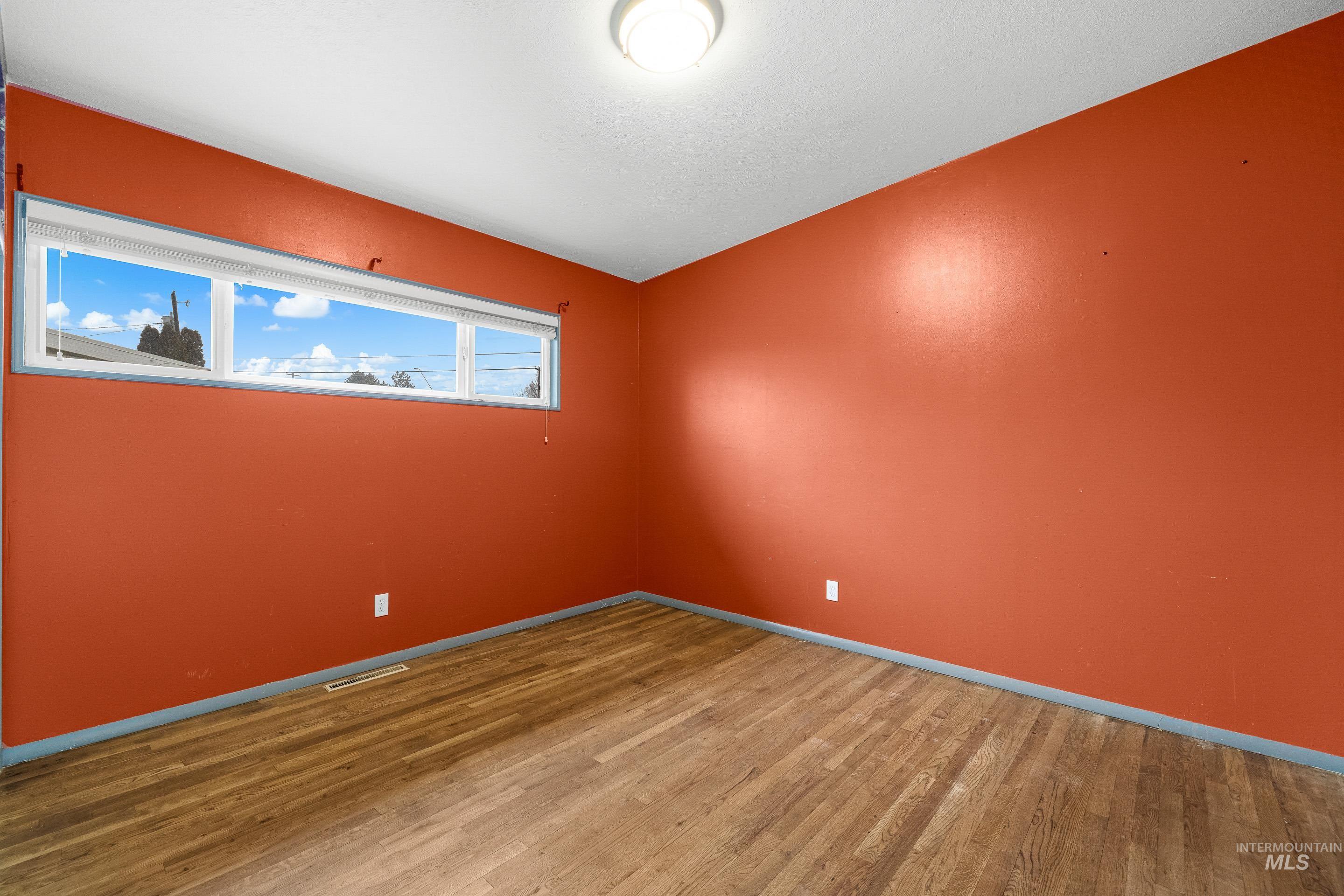 Empty room featuring wood finished floors and baseboards