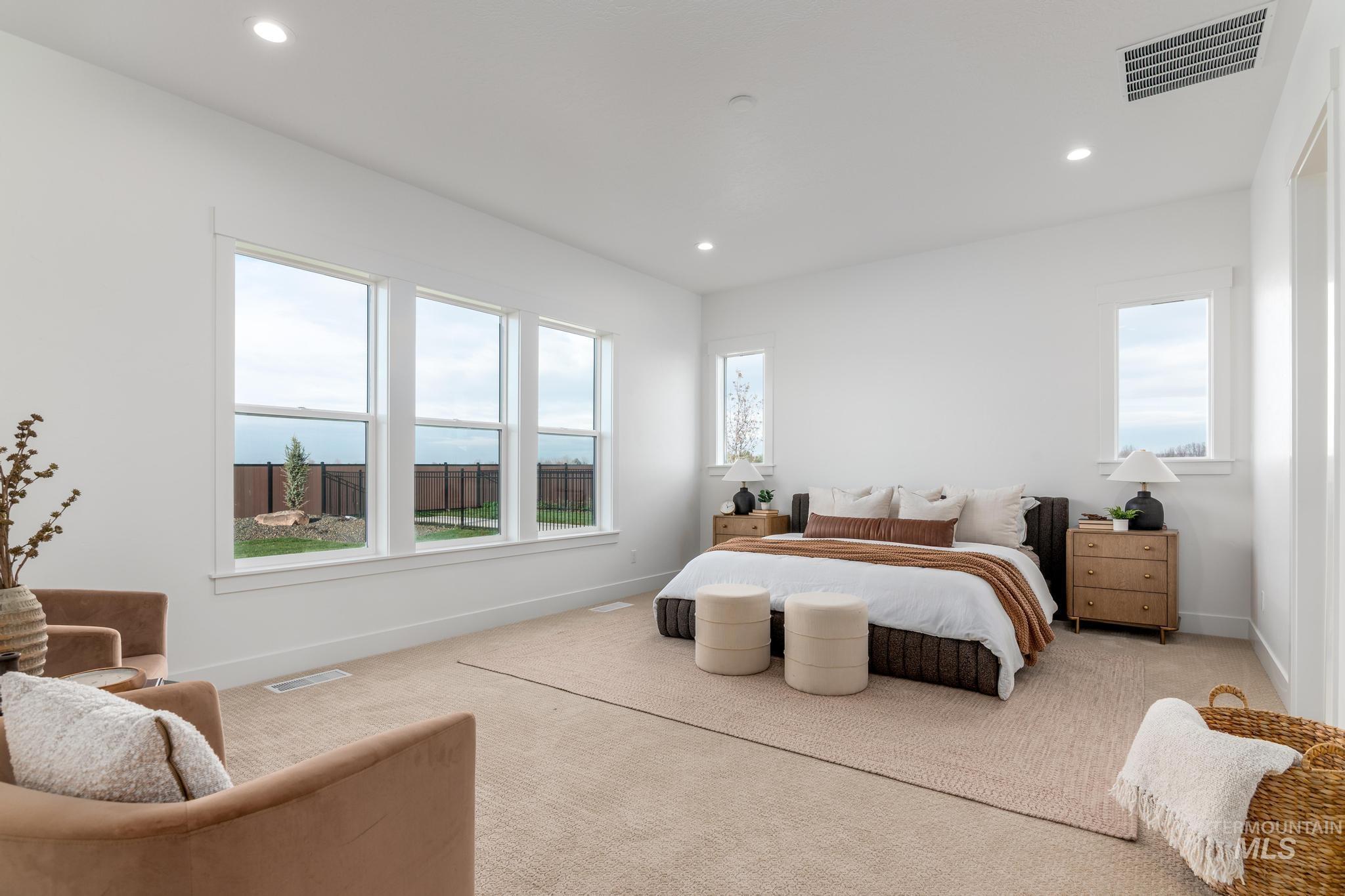 Expansive bedroom featuring large windows, recessed lighting, and light-toned carpeting
