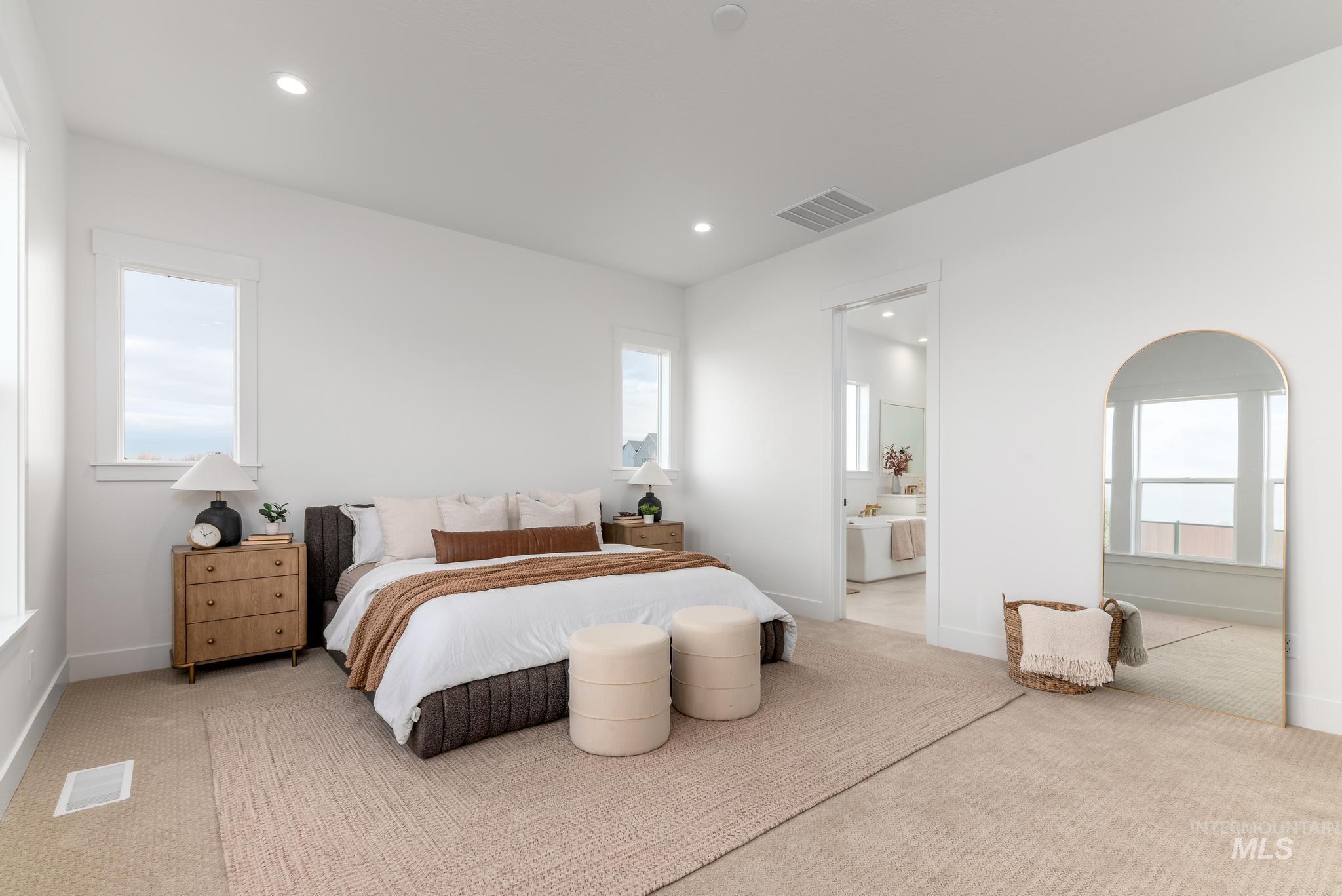 Spacious bedroom featuring multiple windows, recessed lighting, and soft carpet flooring