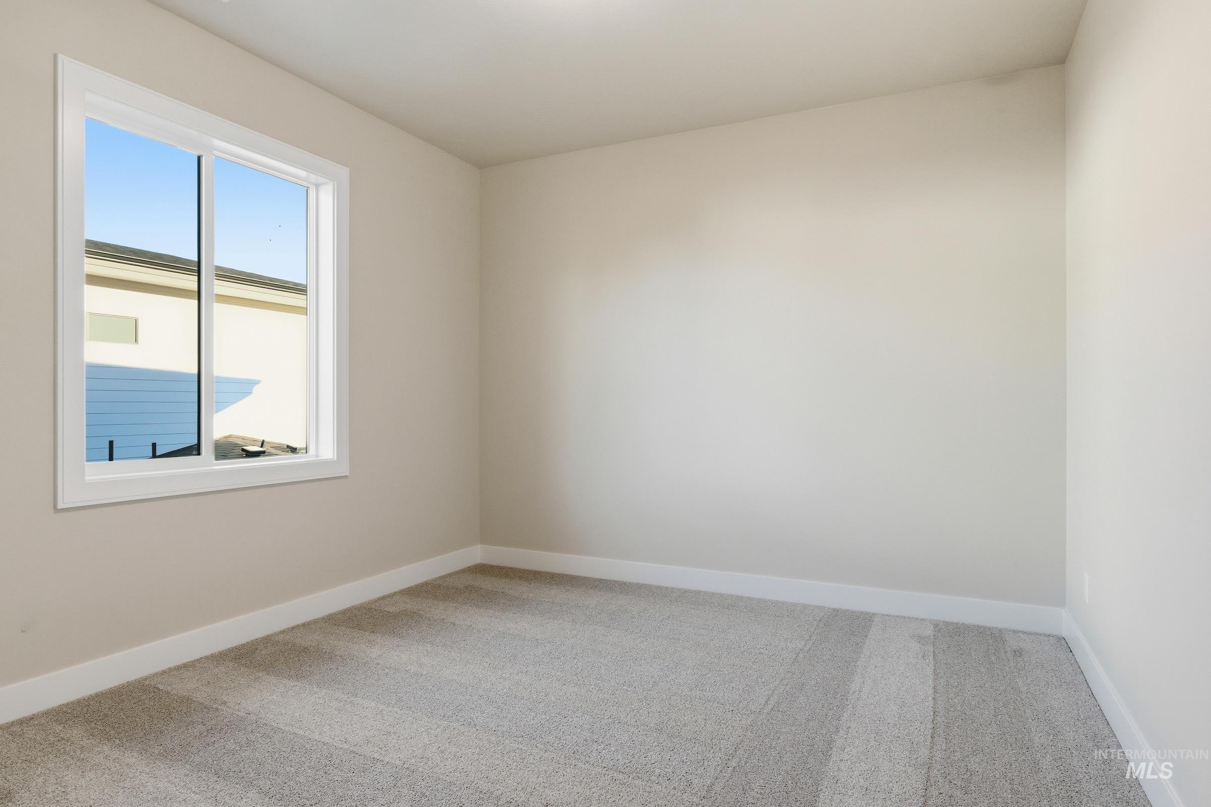 Spare room with light carpet and baseboards