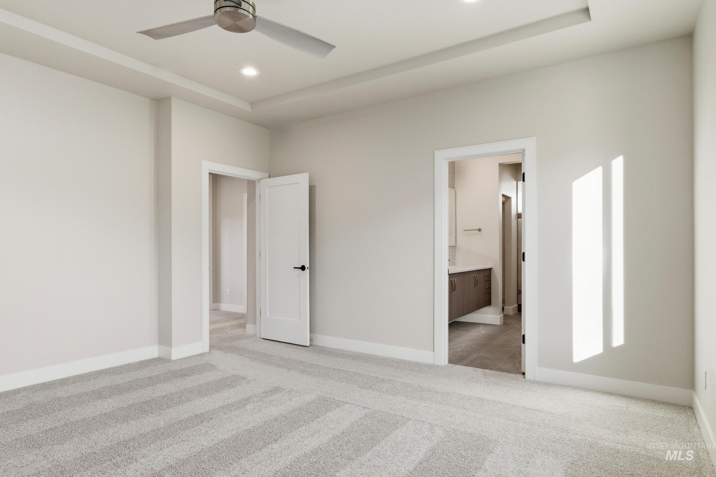 Unfurnished bedroom featuring light colored carpet, ceiling fan, ensuite bathroom, and recessed lighting