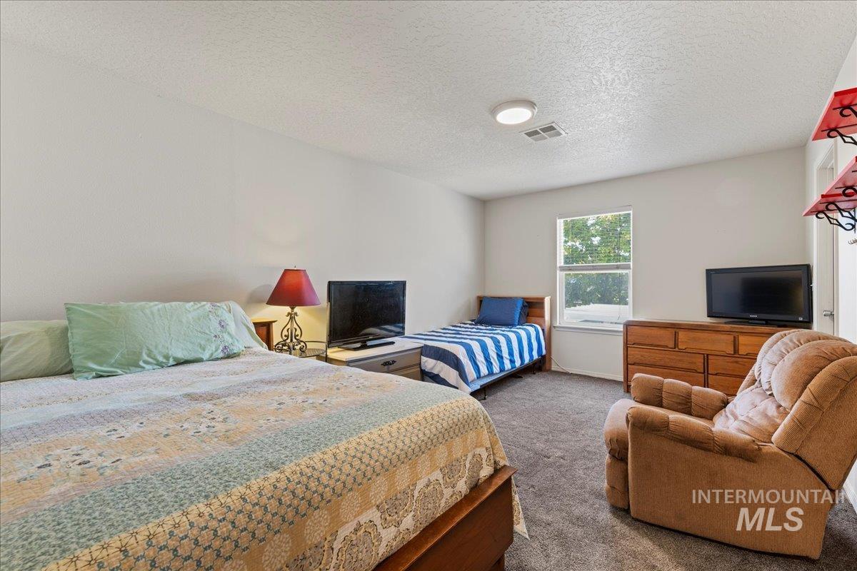 Carpeted bedroom with a textured ceiling