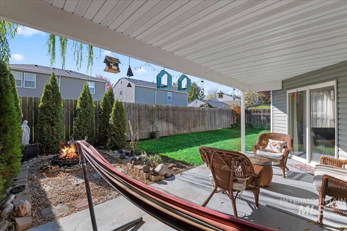 Fenced backyard with a patio and an outdoor living space with a fire pit