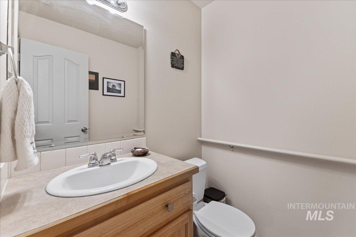 Half bath featuring vanity and a textured wall
