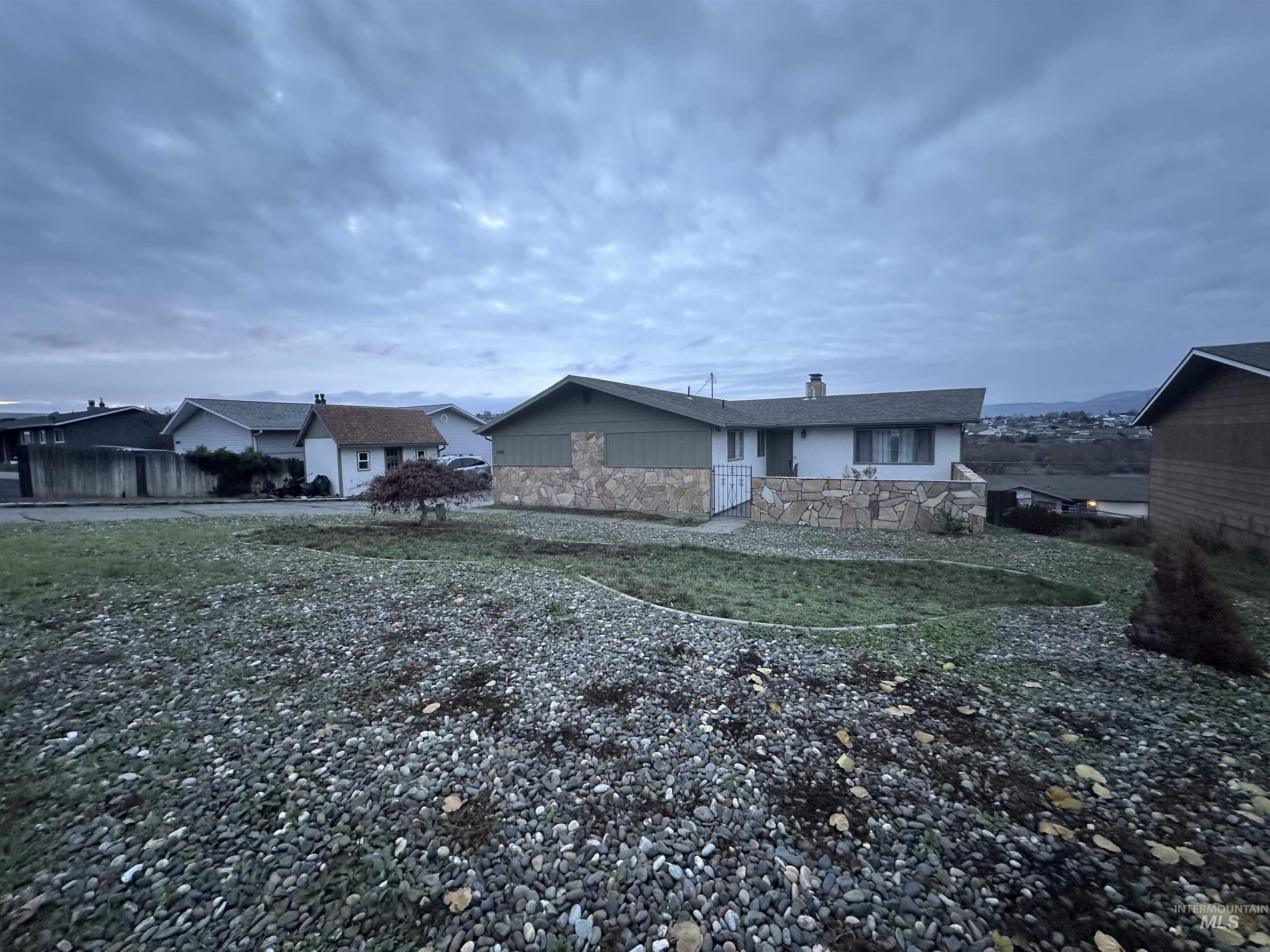 Back of property featuring stone siding and a chimney