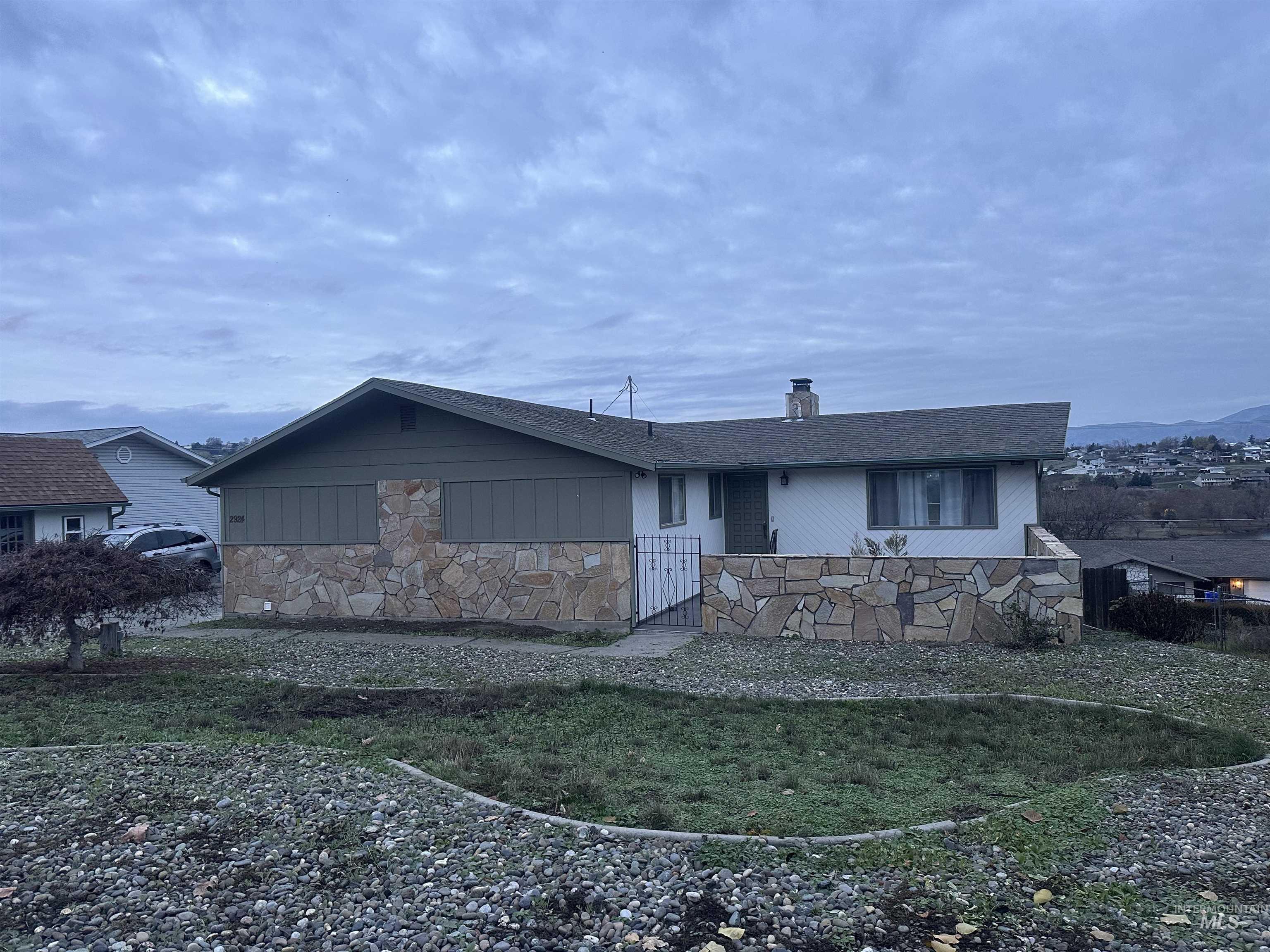 View of front of house with a chimney and stone siding