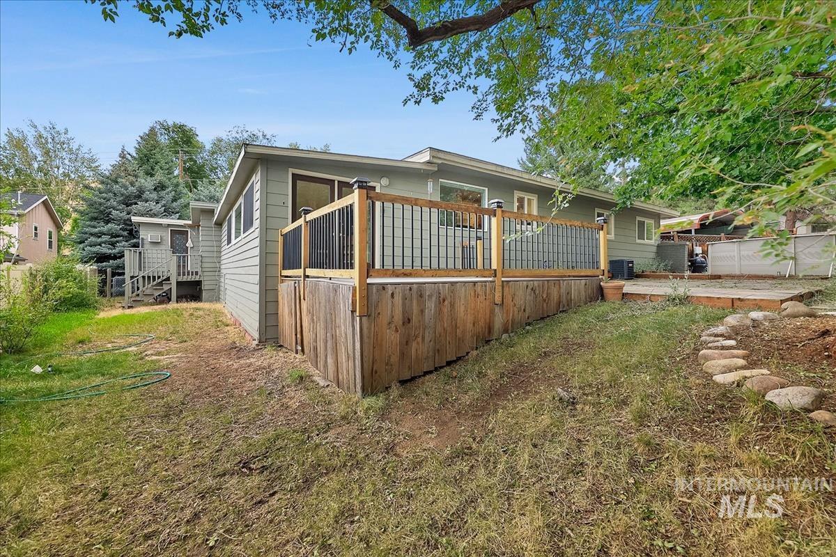 Wood-sided exterior featuring a spacious deck with wood railing and black balusters