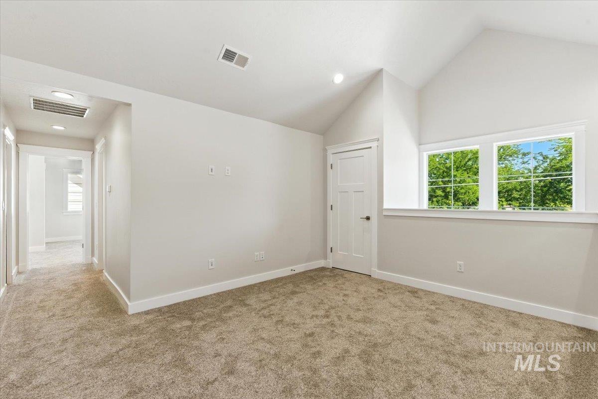 Spare room featuring carpet floors, lofted ceiling, and recessed lighting