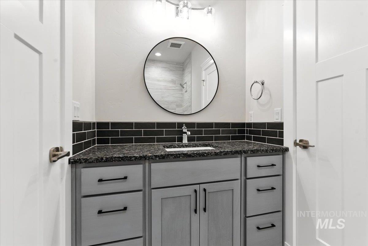 Bathroom with vanity and decorative backsplash