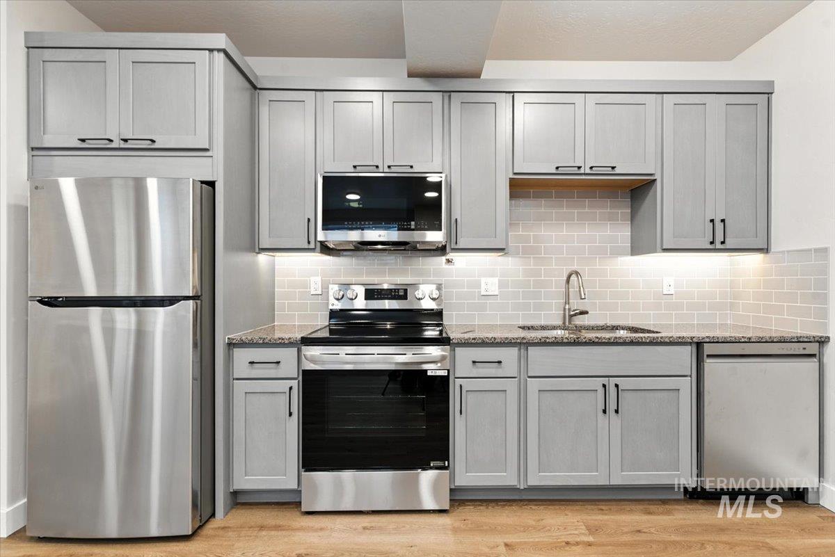 Kitchen featuring appliances with stainless steel finishes and gray cabinetry