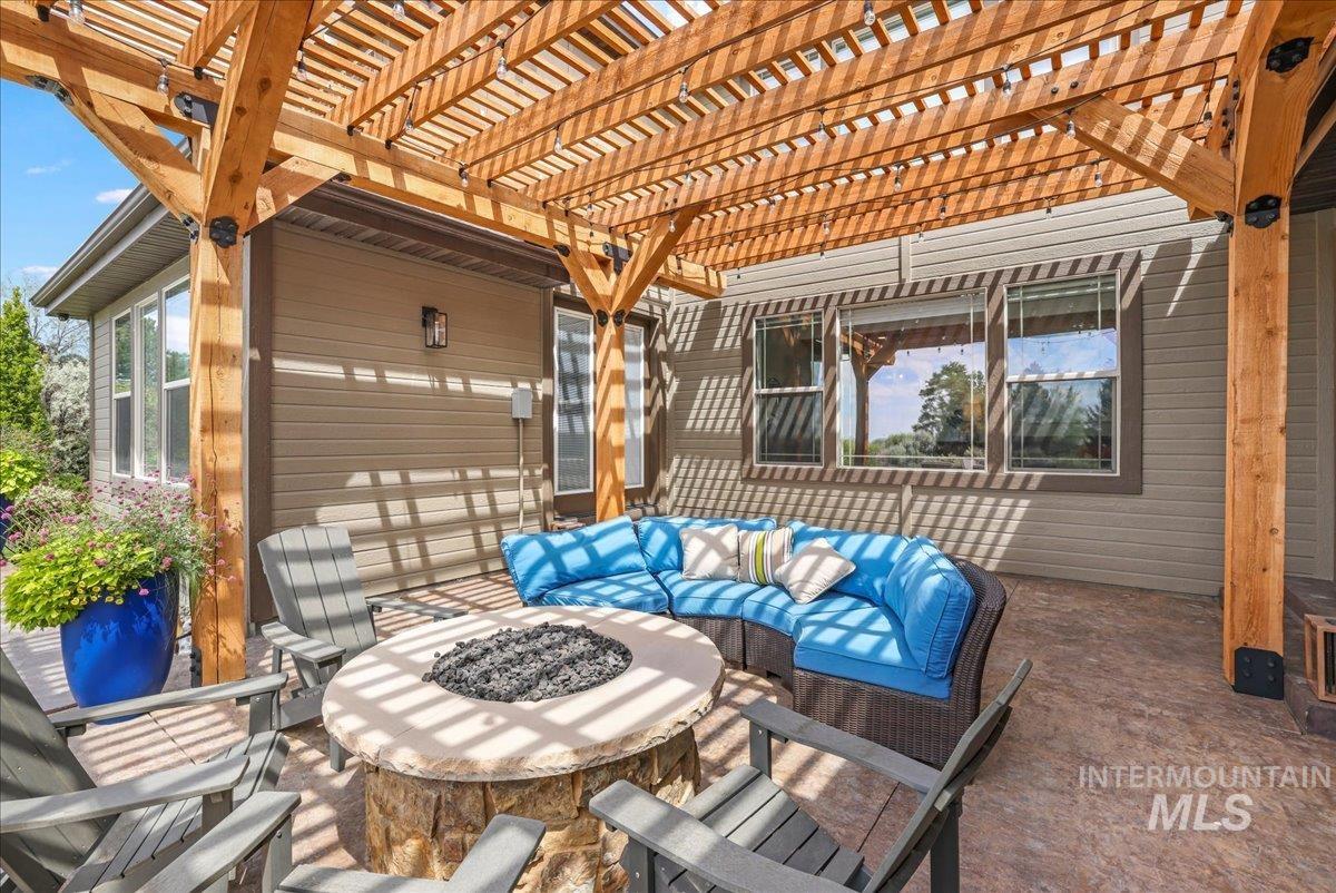 View of patio / terrace with a pergola and an outdoor living space with a fire pit