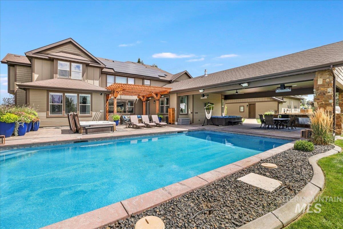 Swimming pool featuring a hot tub, a patio area, and a pergola